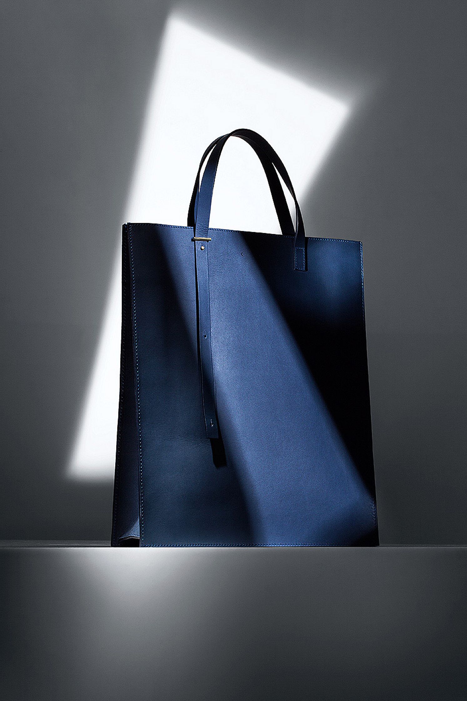 a blue tote bag with a light shining on it - Bildbearbeitung Hamburg