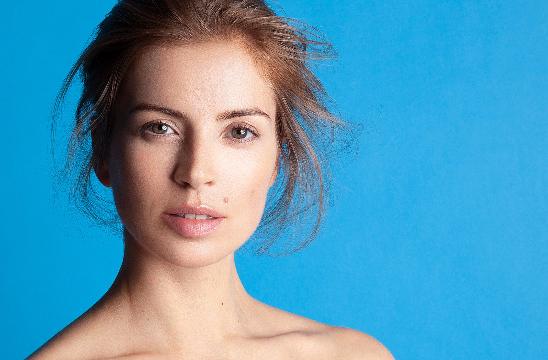 a young woman posing against a blue background beauty bildbearbeitung