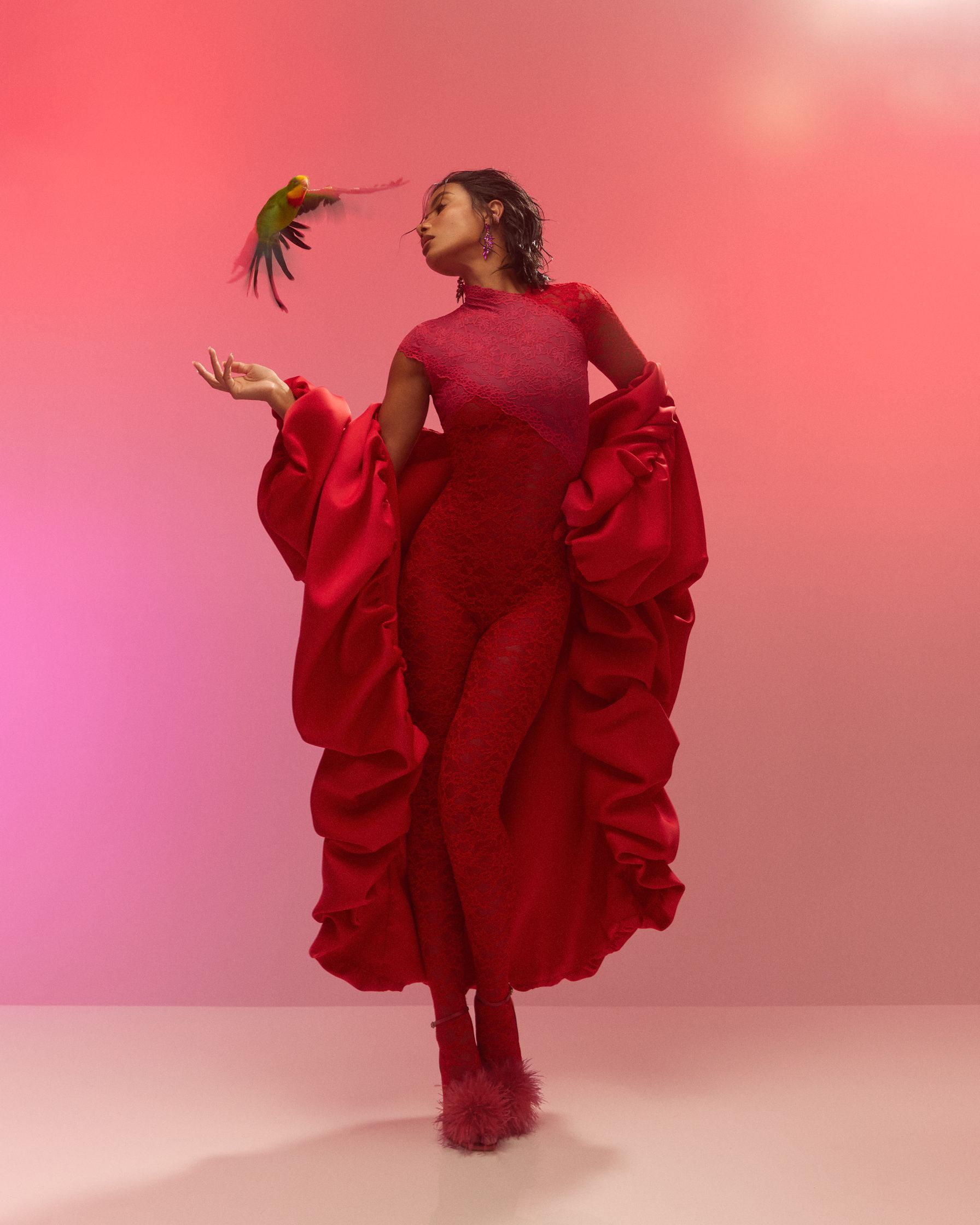 a woman in a red dress holding a parrot