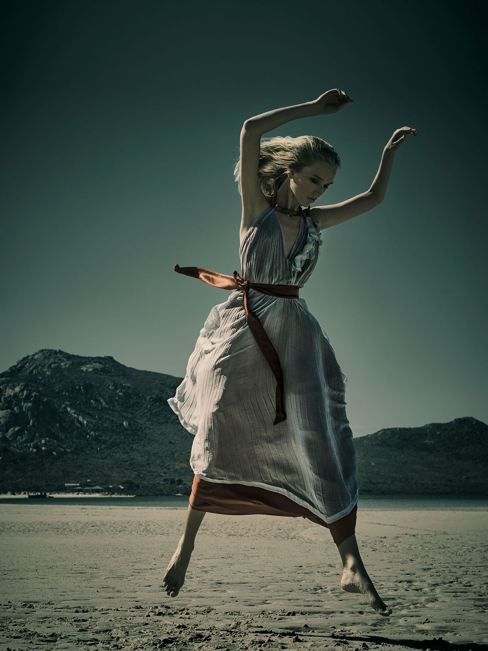 a woman in a dress jumping in the air