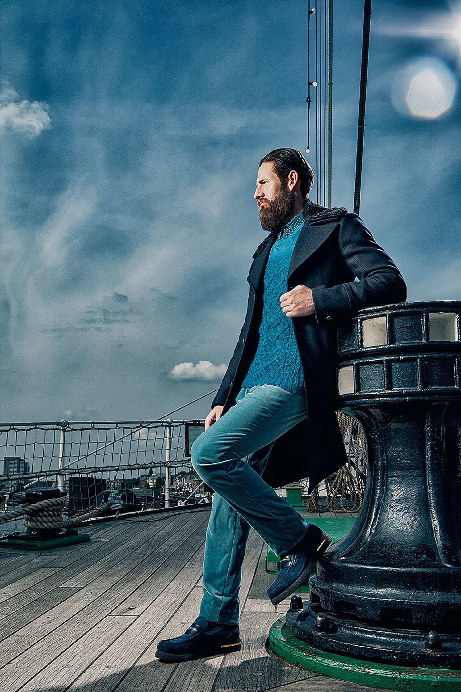 a man with a beard leaning against a railing Creative Retouching Hamburg