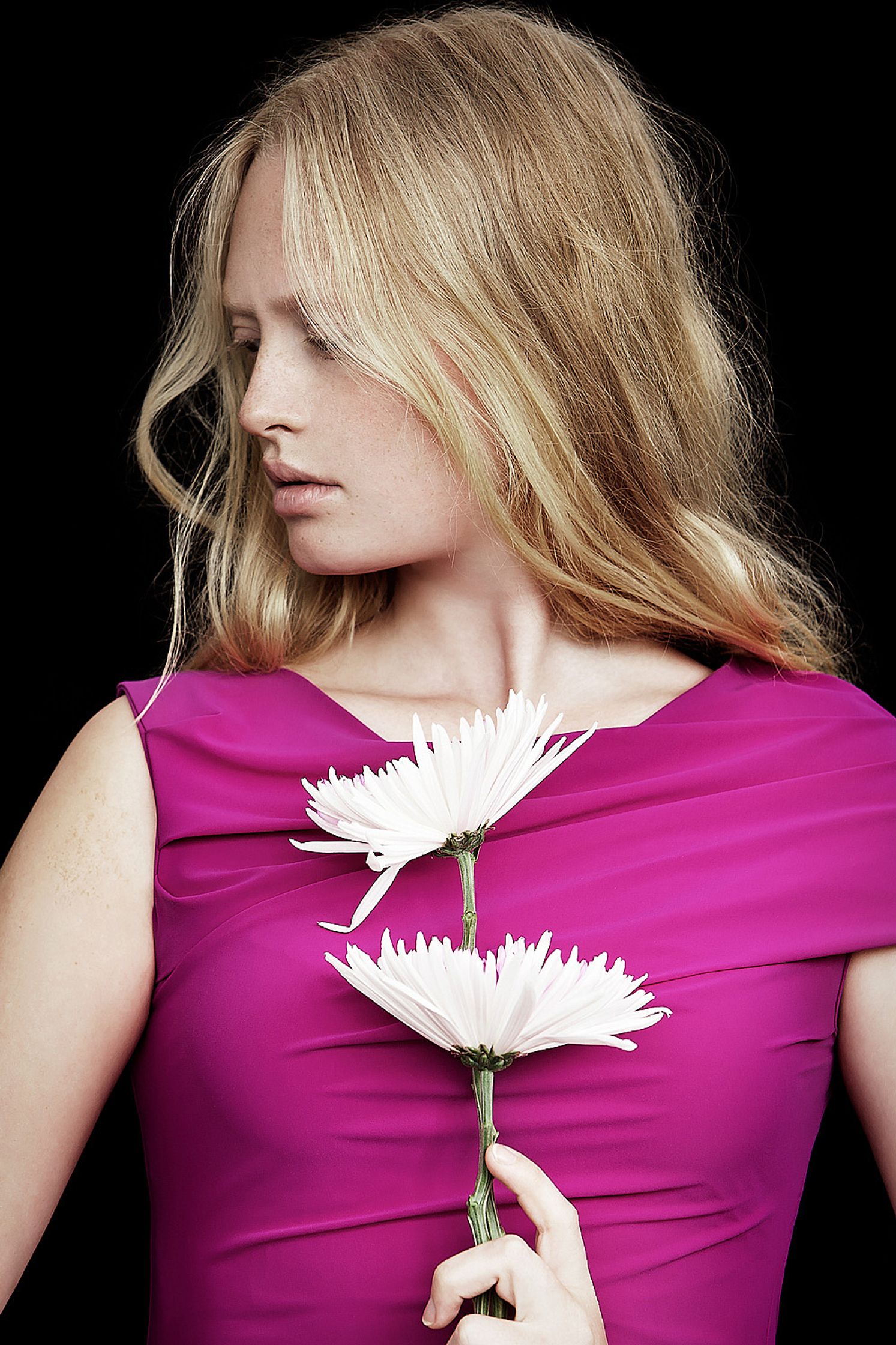 a woman in a pink dress holding two white flowers natural retouch campaign