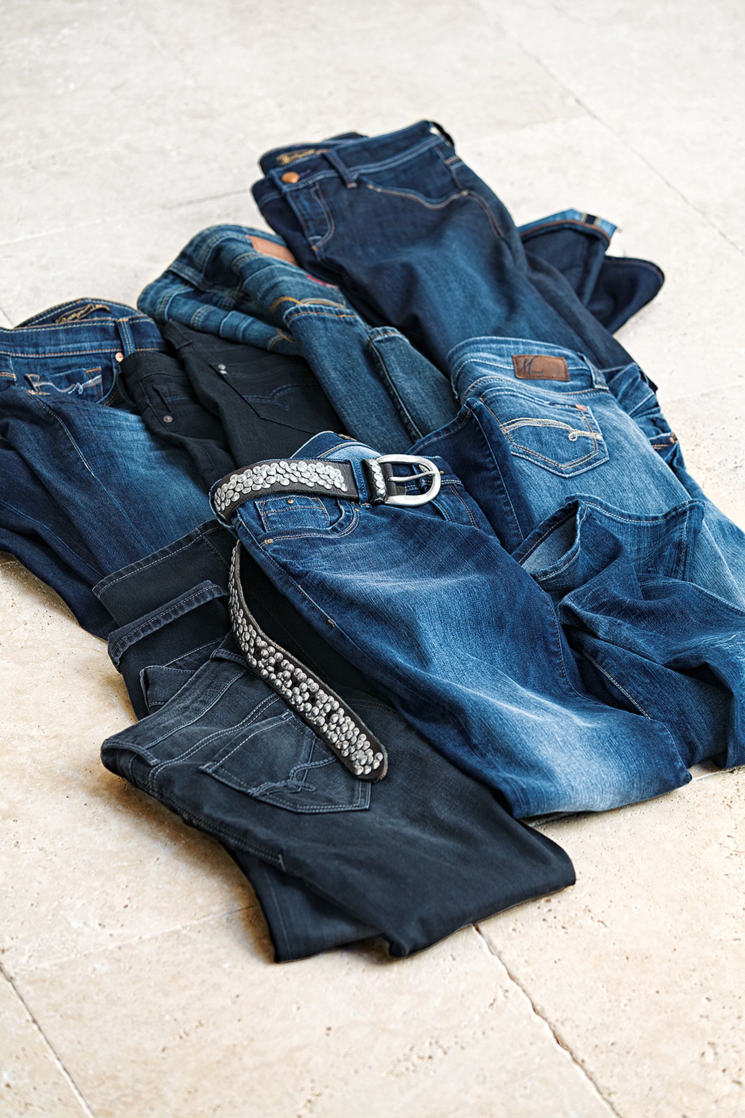 a pile of jeans on a tile floor Bildbearbeitung Hamburg