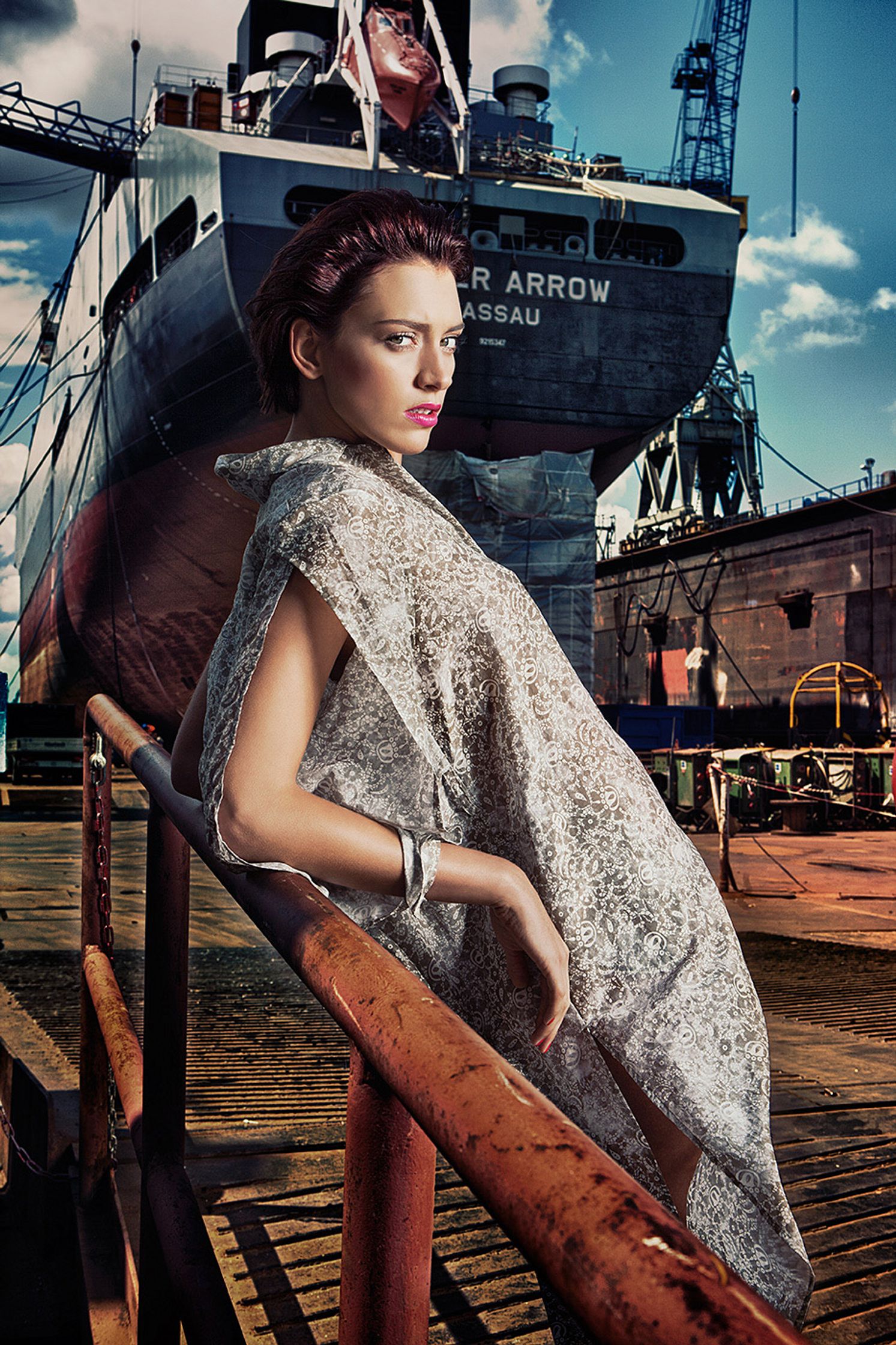 a woman is posing in front of a ship fashion image campaign