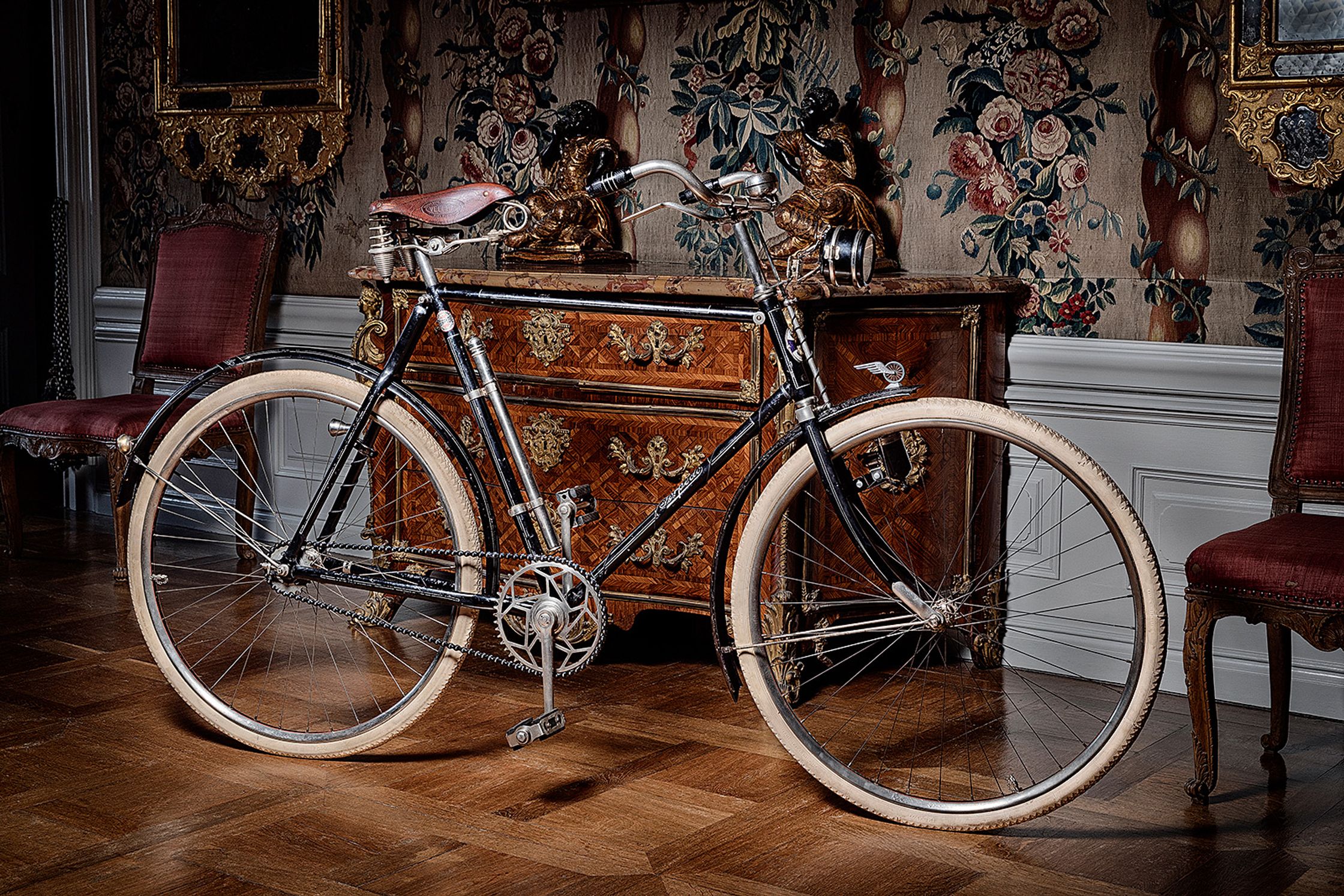 a bicycle is parked in front of a chair product Post Production