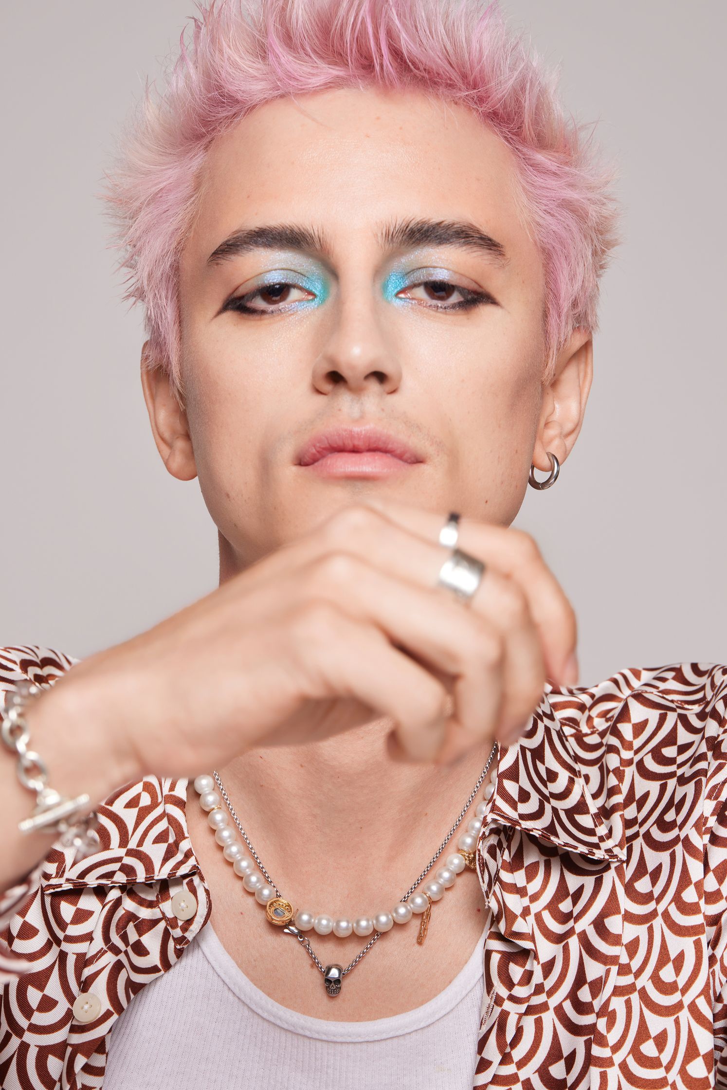 a young man with pink hair posing for a photo