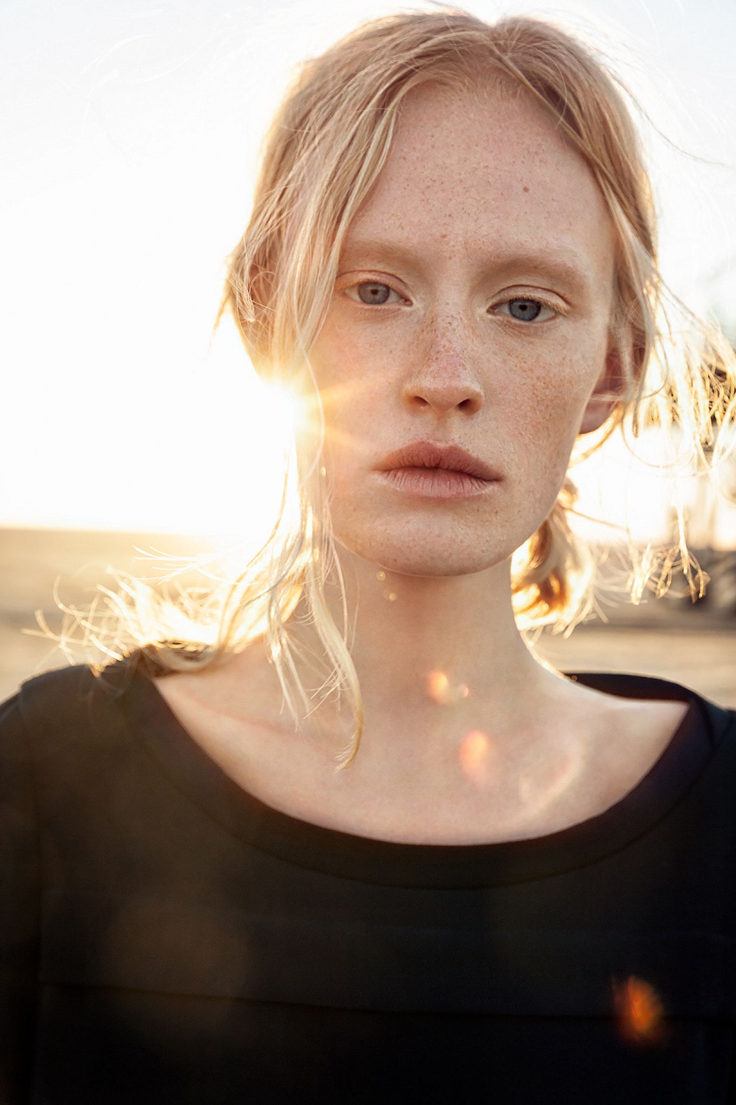 a woman with freckles standing in the sun retouche advertising campaign