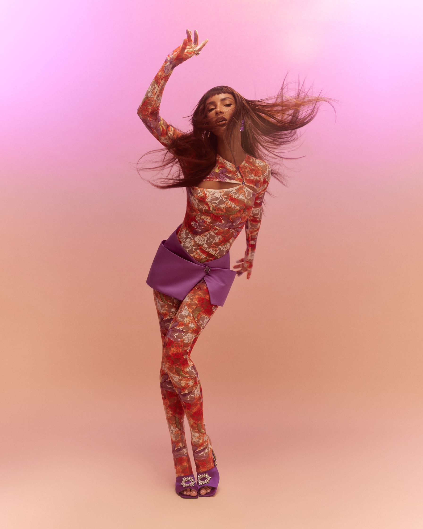 a woman with long hair is dancing on a pink background