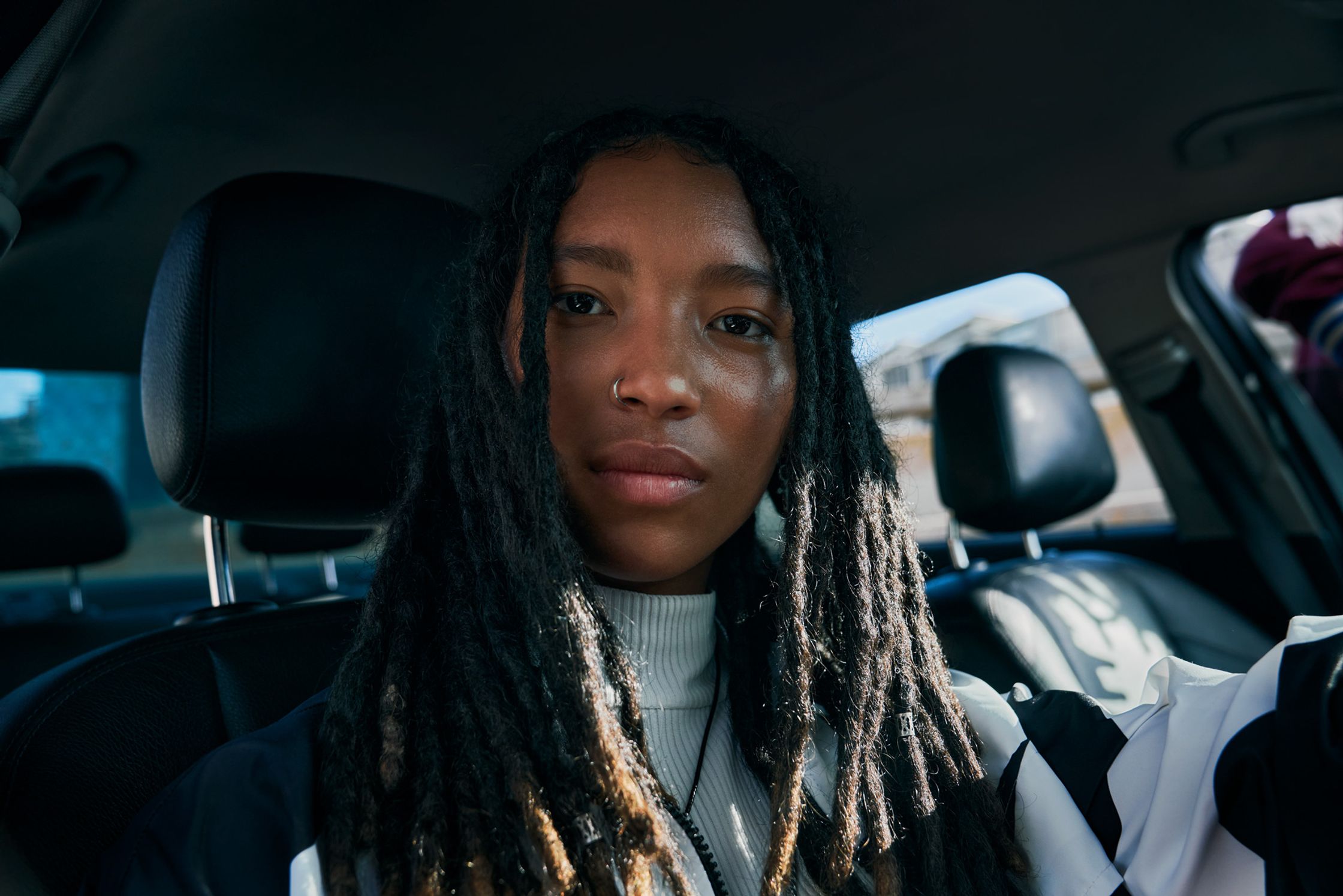 a young woman with dreadlocks sitting in a car