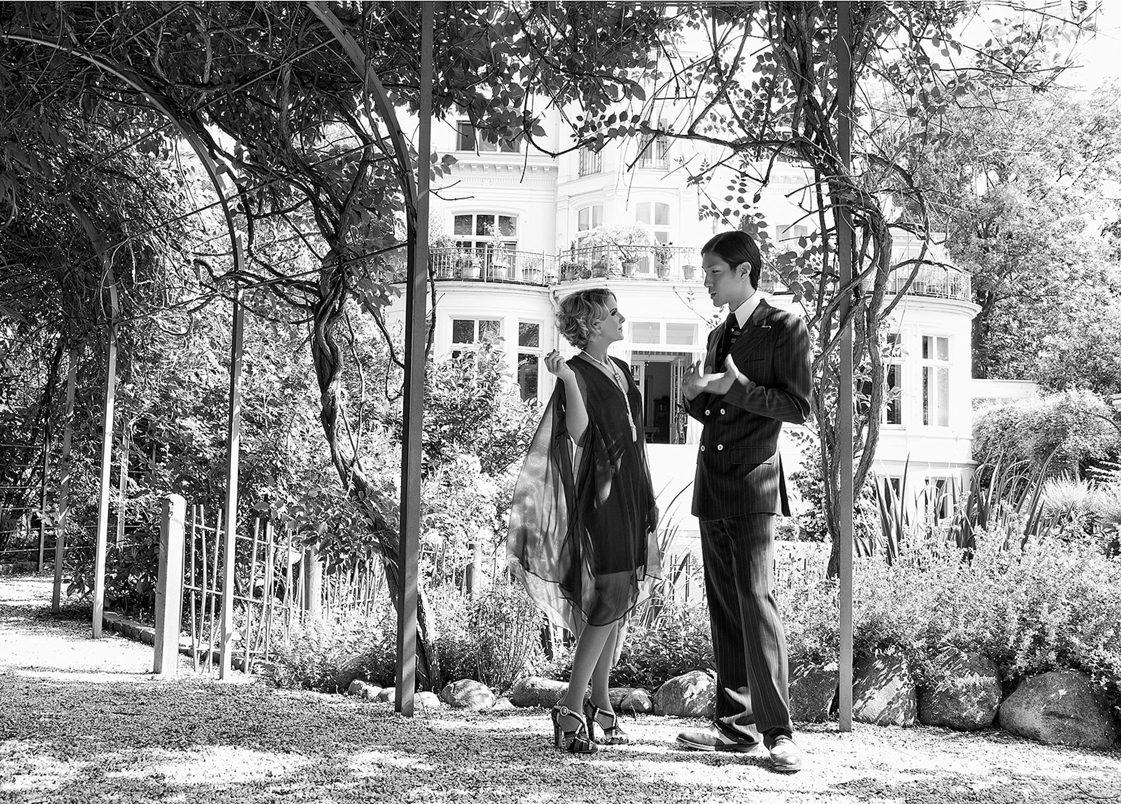 a black and white photo of a couple standing under a tree advertising retouch hamburg