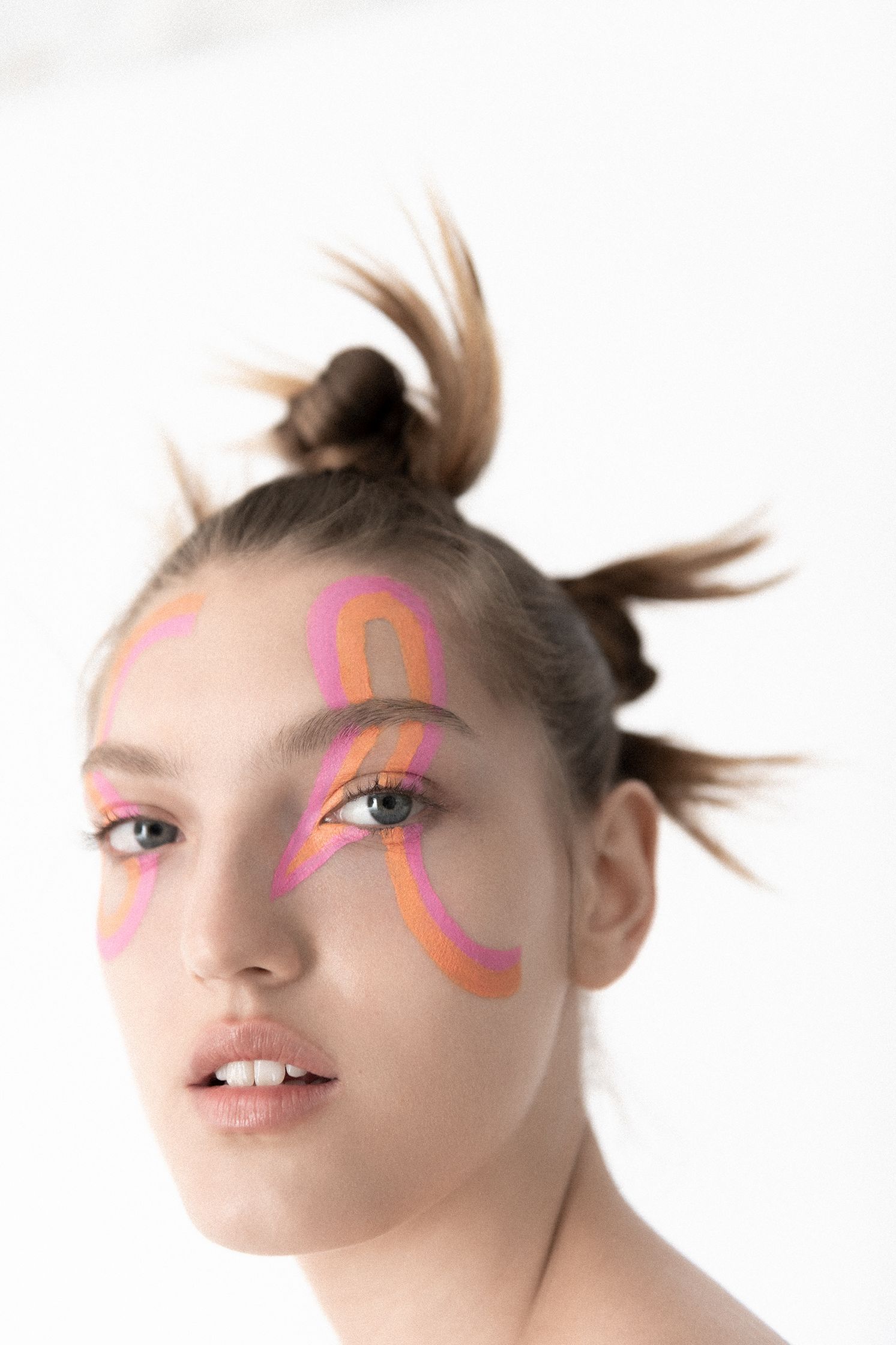 a woman with pink and orange paint on her face