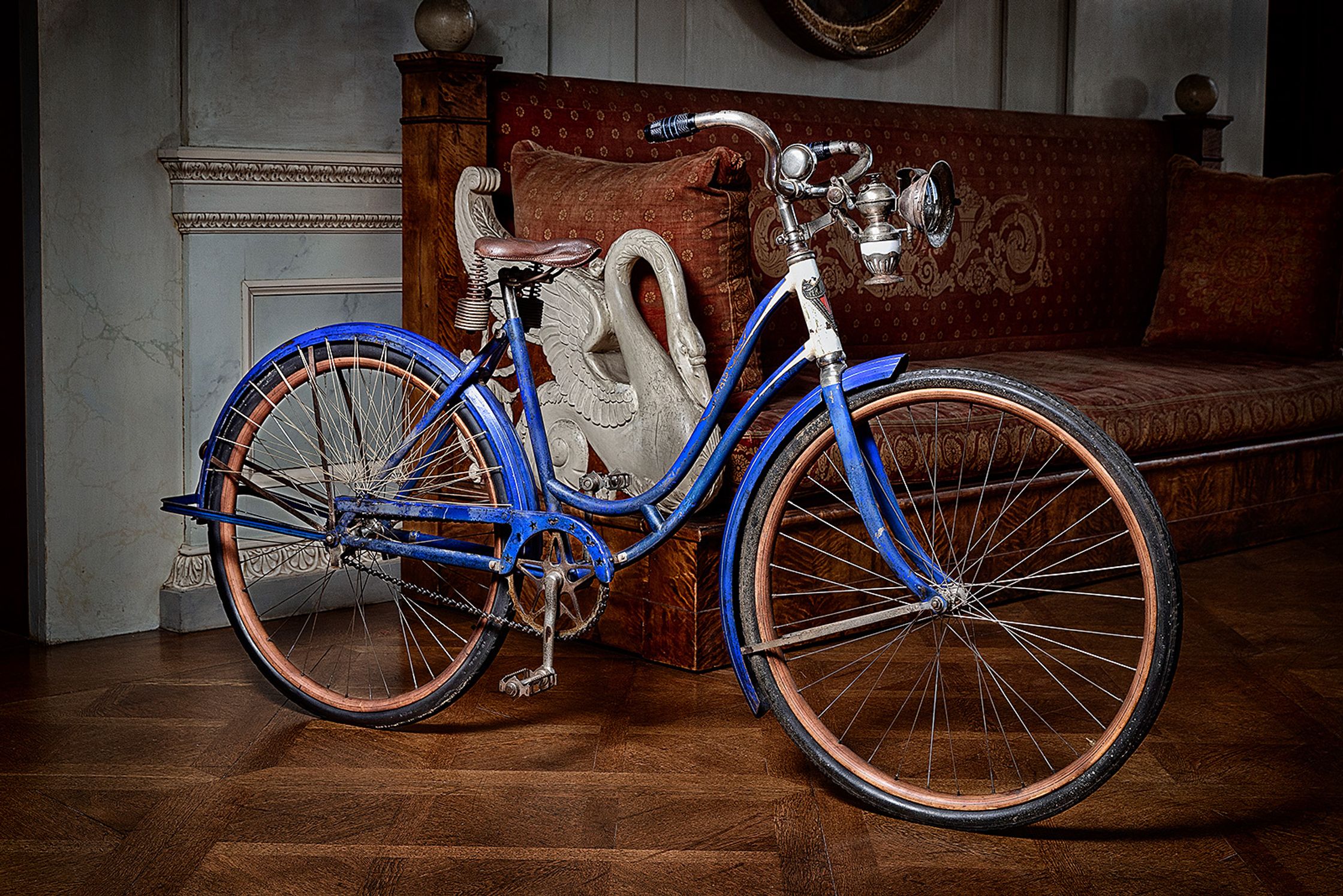 a blue and white bicycle parked in front of a couch product Post Production