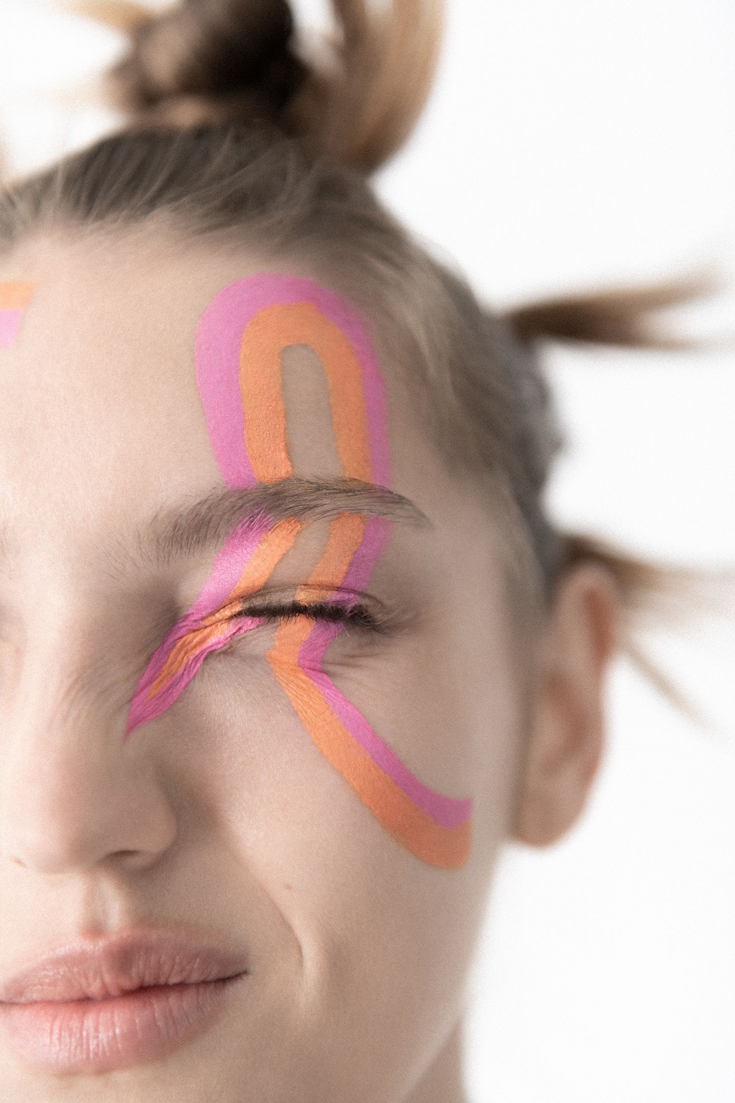 a woman with pink and orange painted on her face