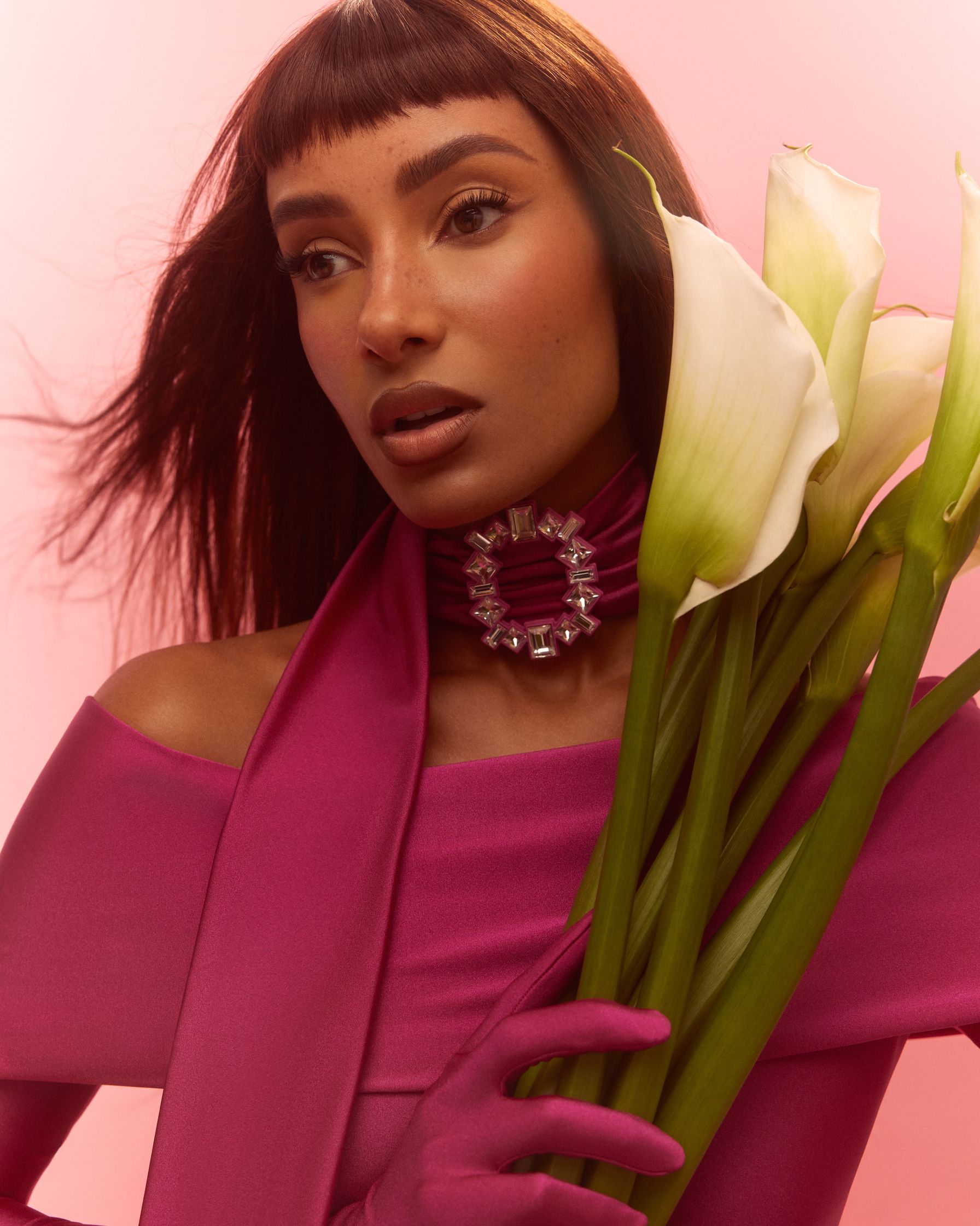 a black woman in a pink dress holding a bouquet of flowers