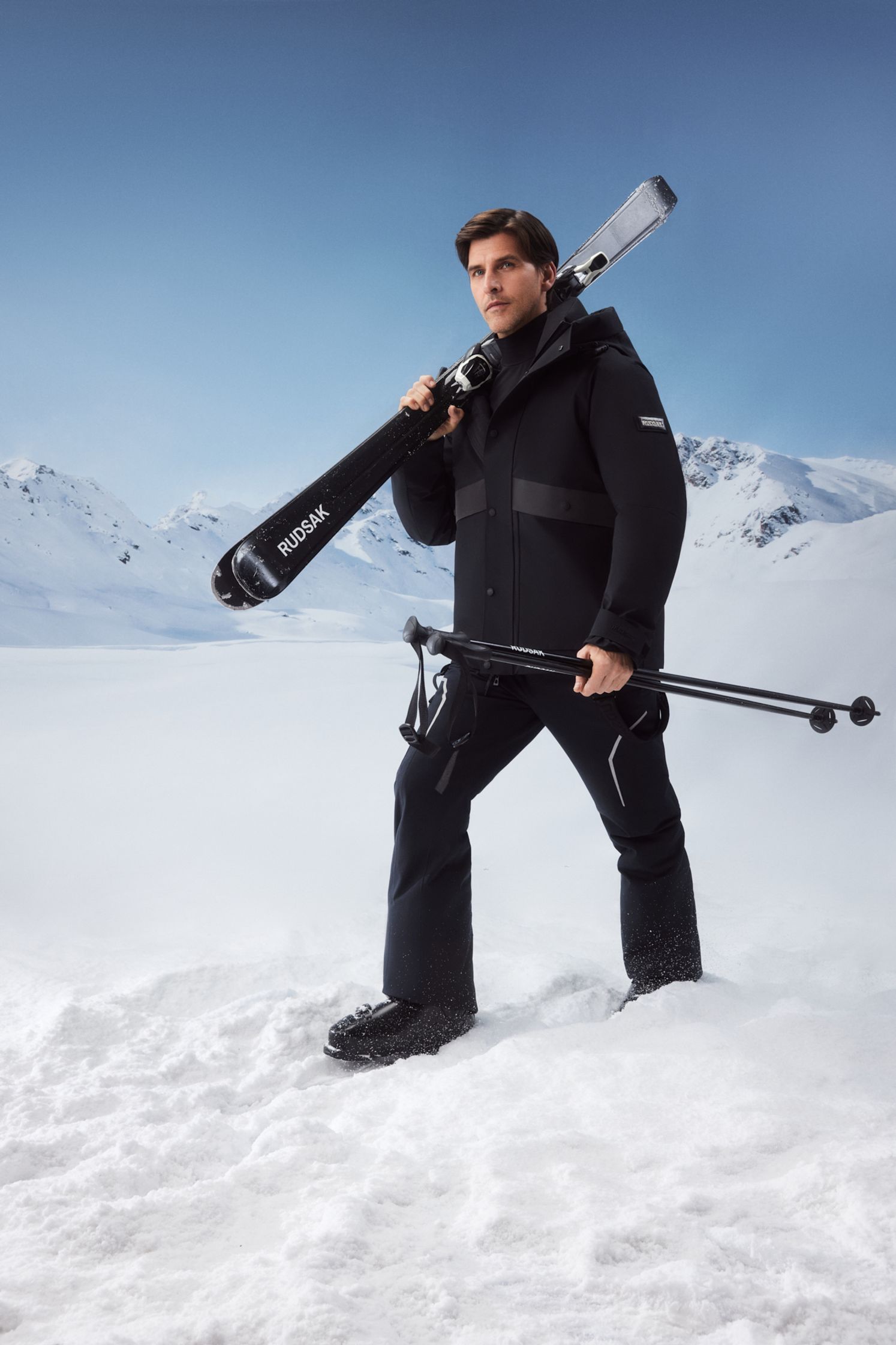 a man holding skis in the snow