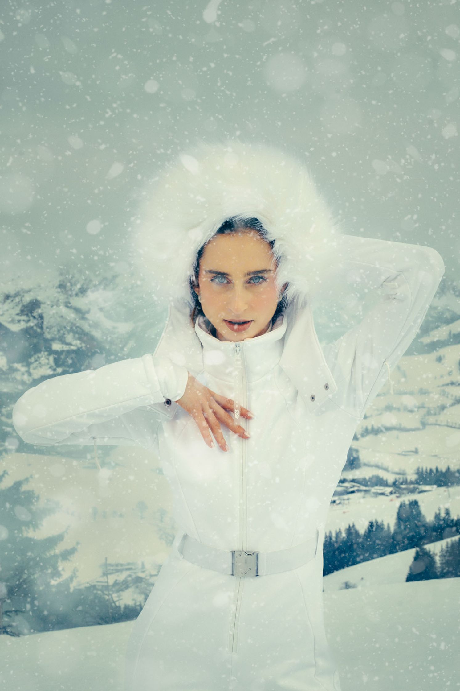 a woman in a white snowsuit posing in the snow