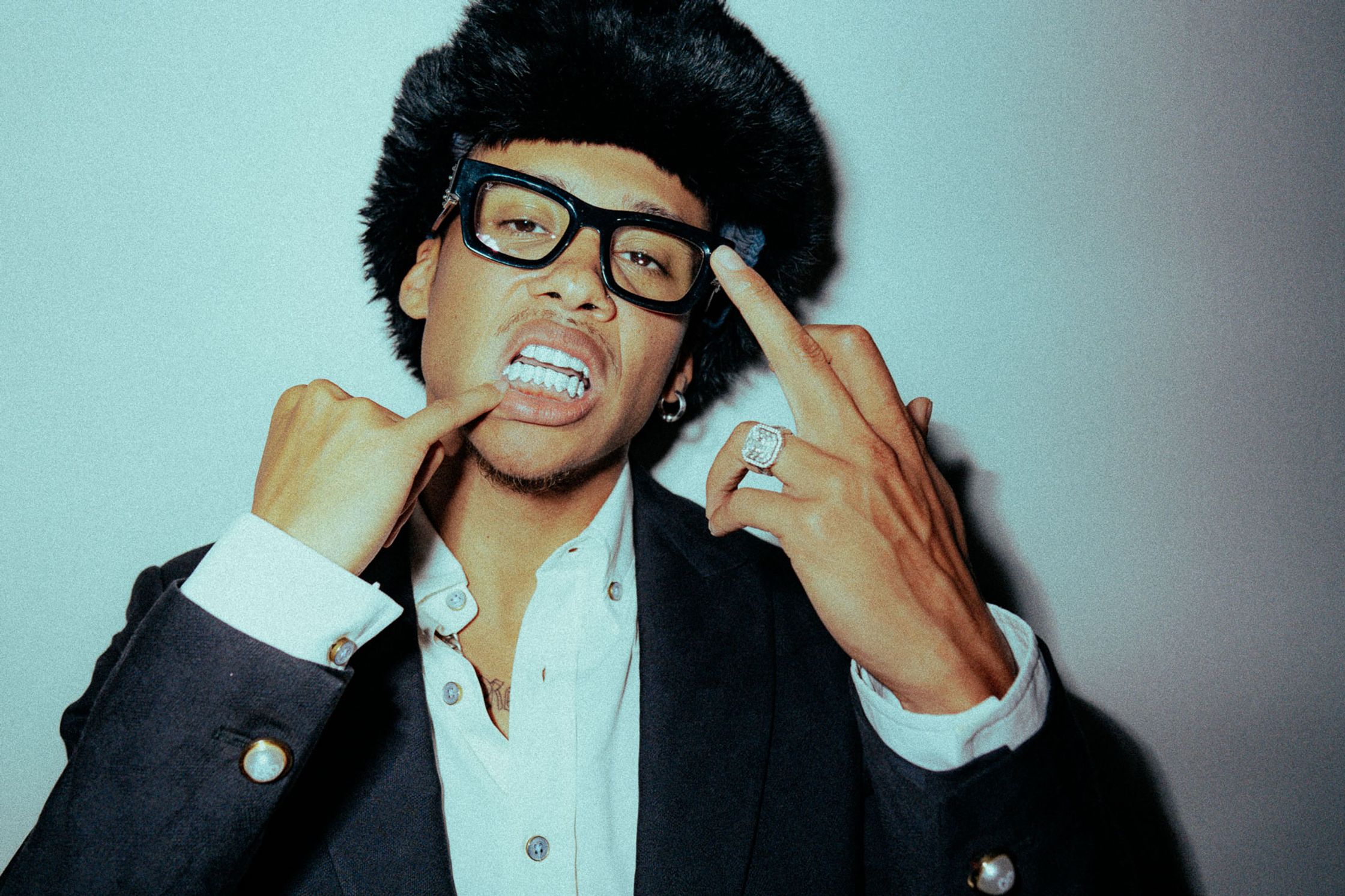 a man wearing glasses and a suit posing for a picture, Kelvyn Colt, Rapper