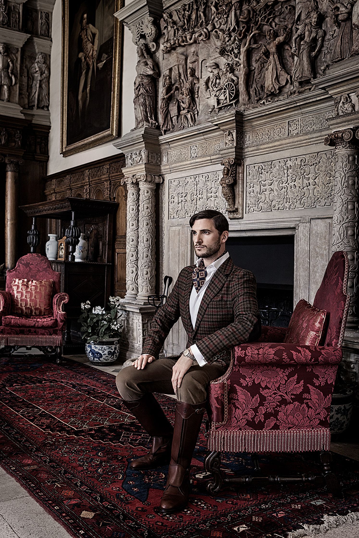 a man sitting on a chair in an ornate room creative post production