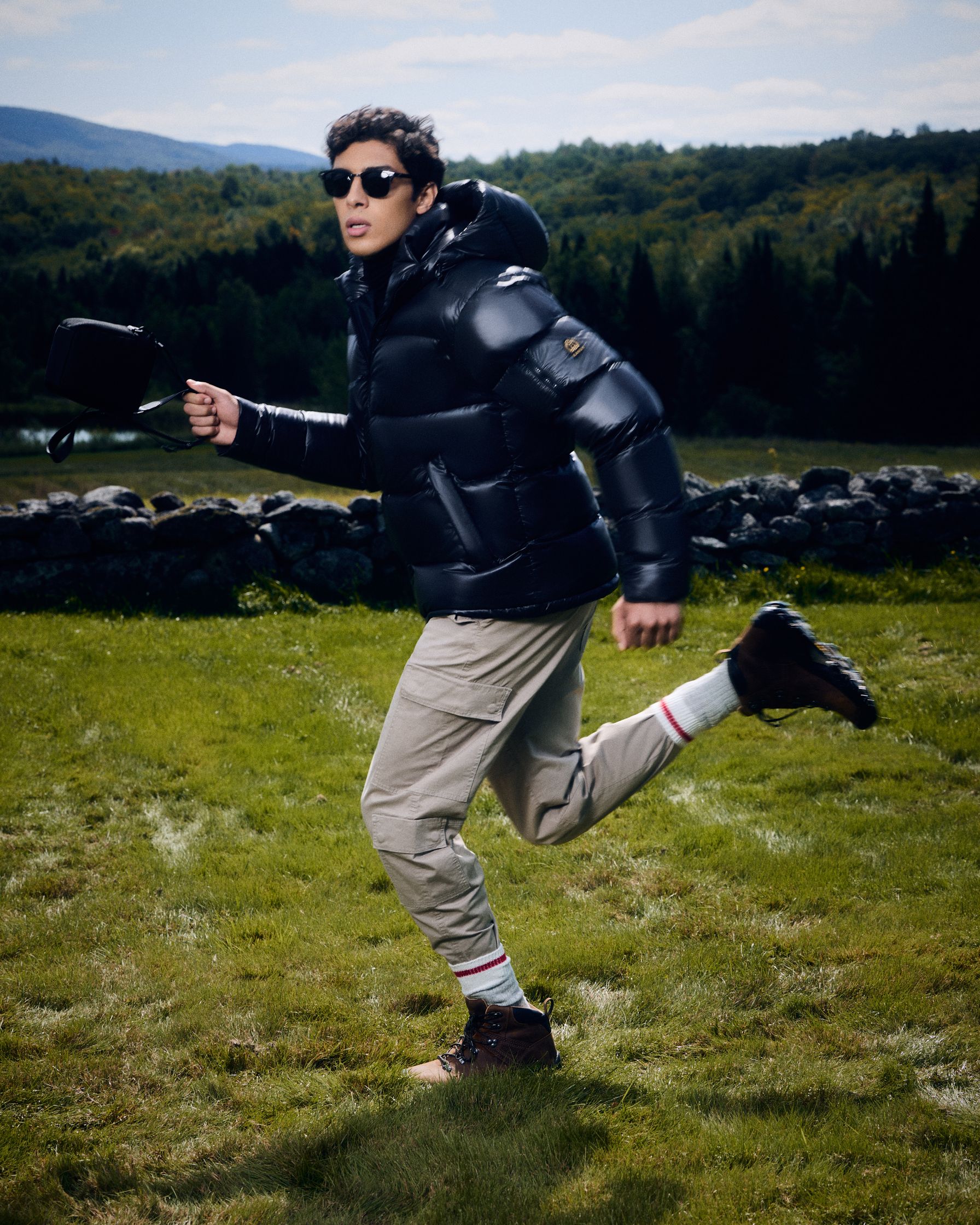 a man in a puffer jacket running in a field