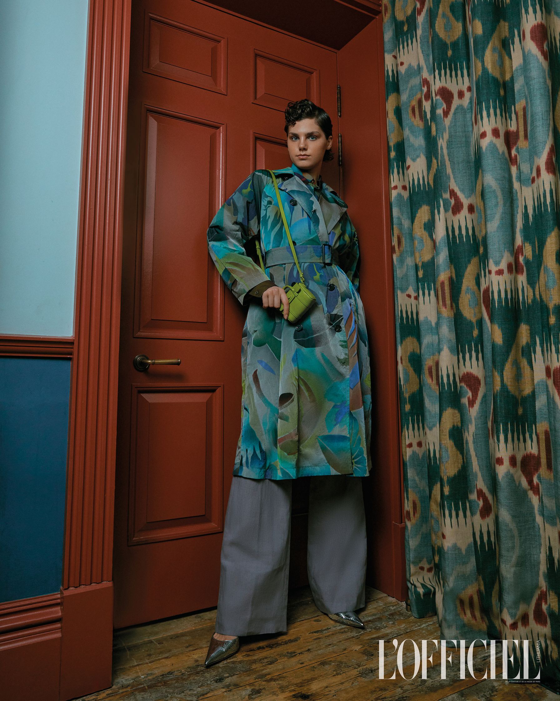 a woman in a colorful coat standing in front of a door