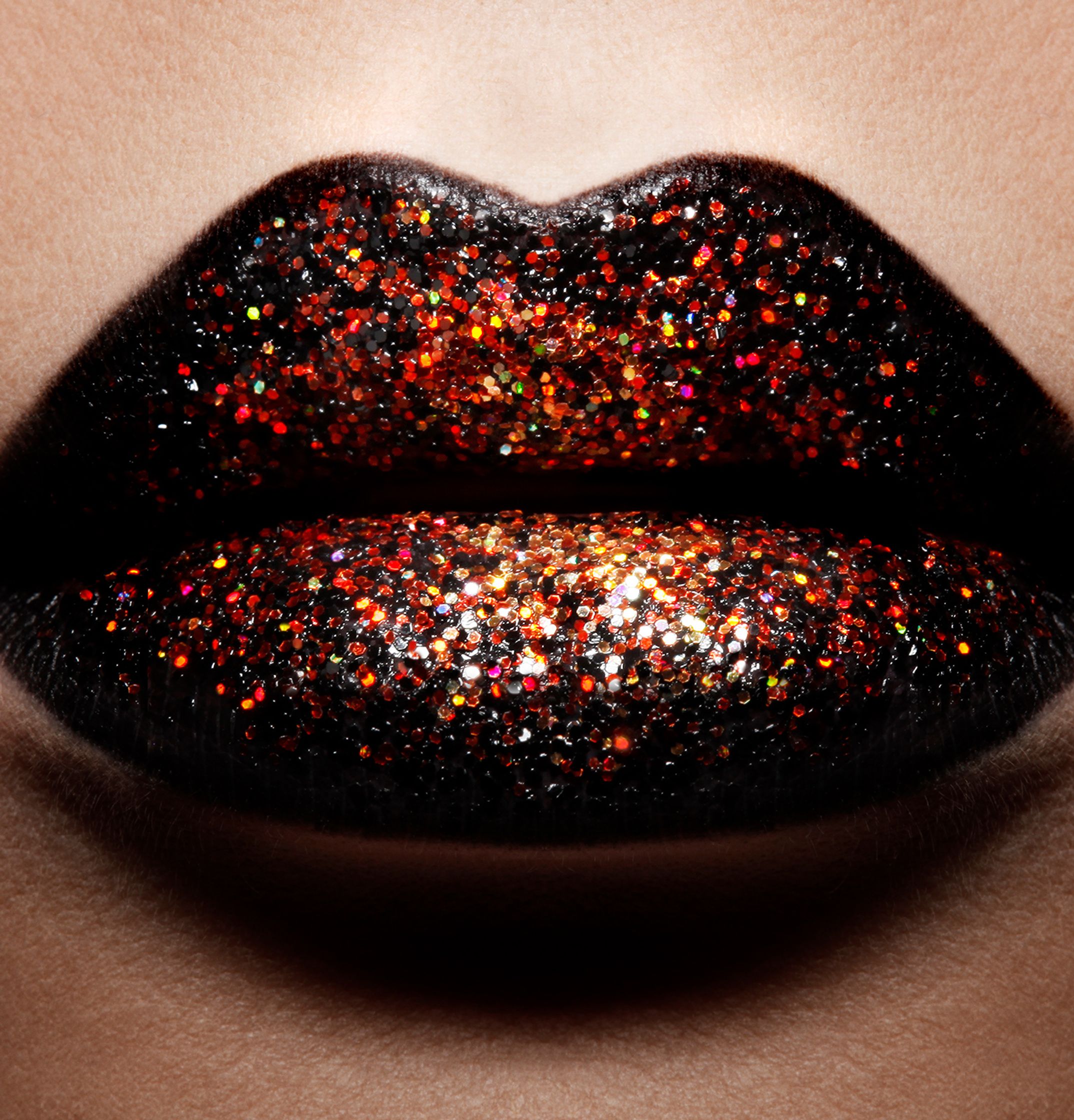 a close up of a woman's lips with black and orange glitter glamour retouch