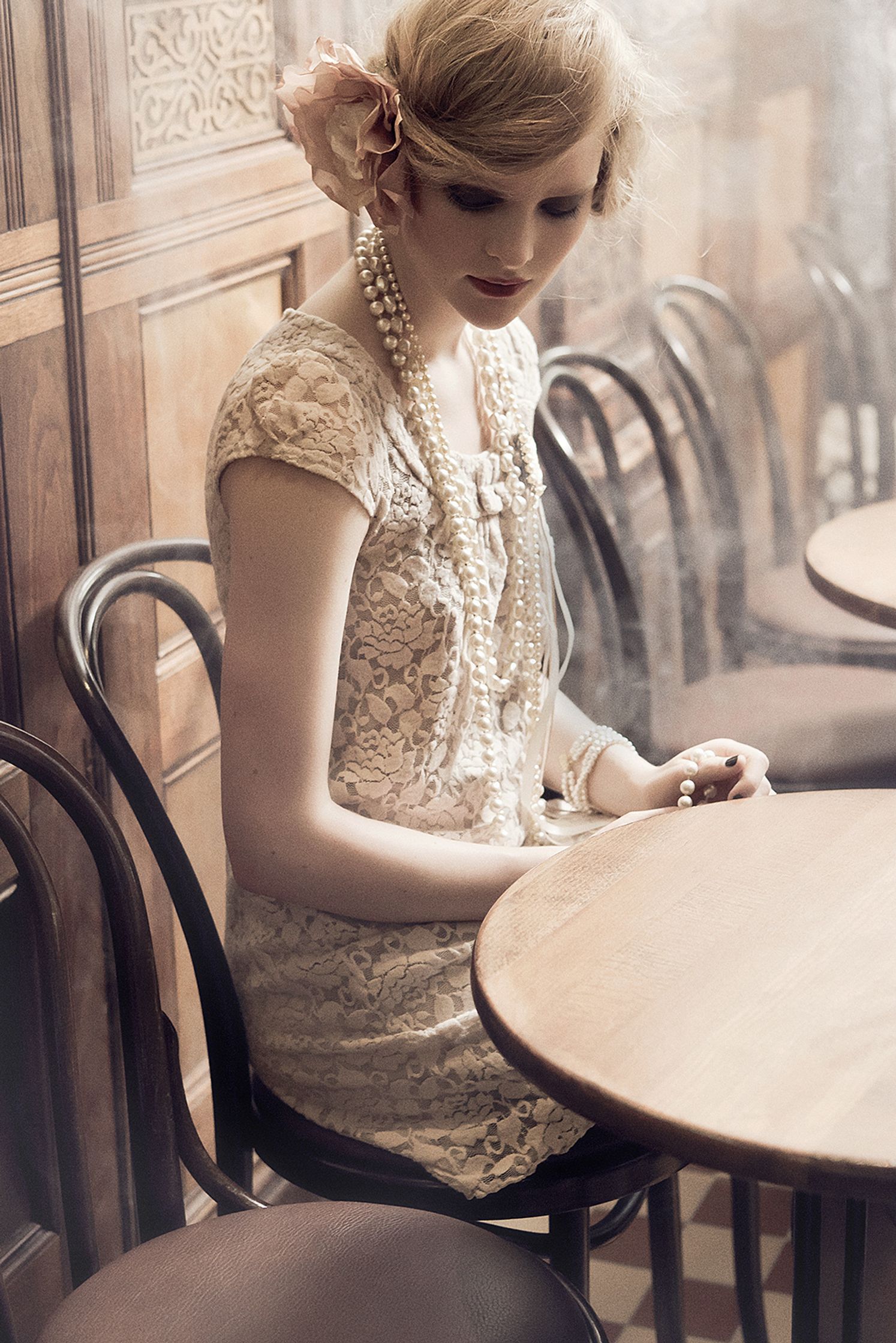 a woman in a white dress sitting at a table fashion retouching