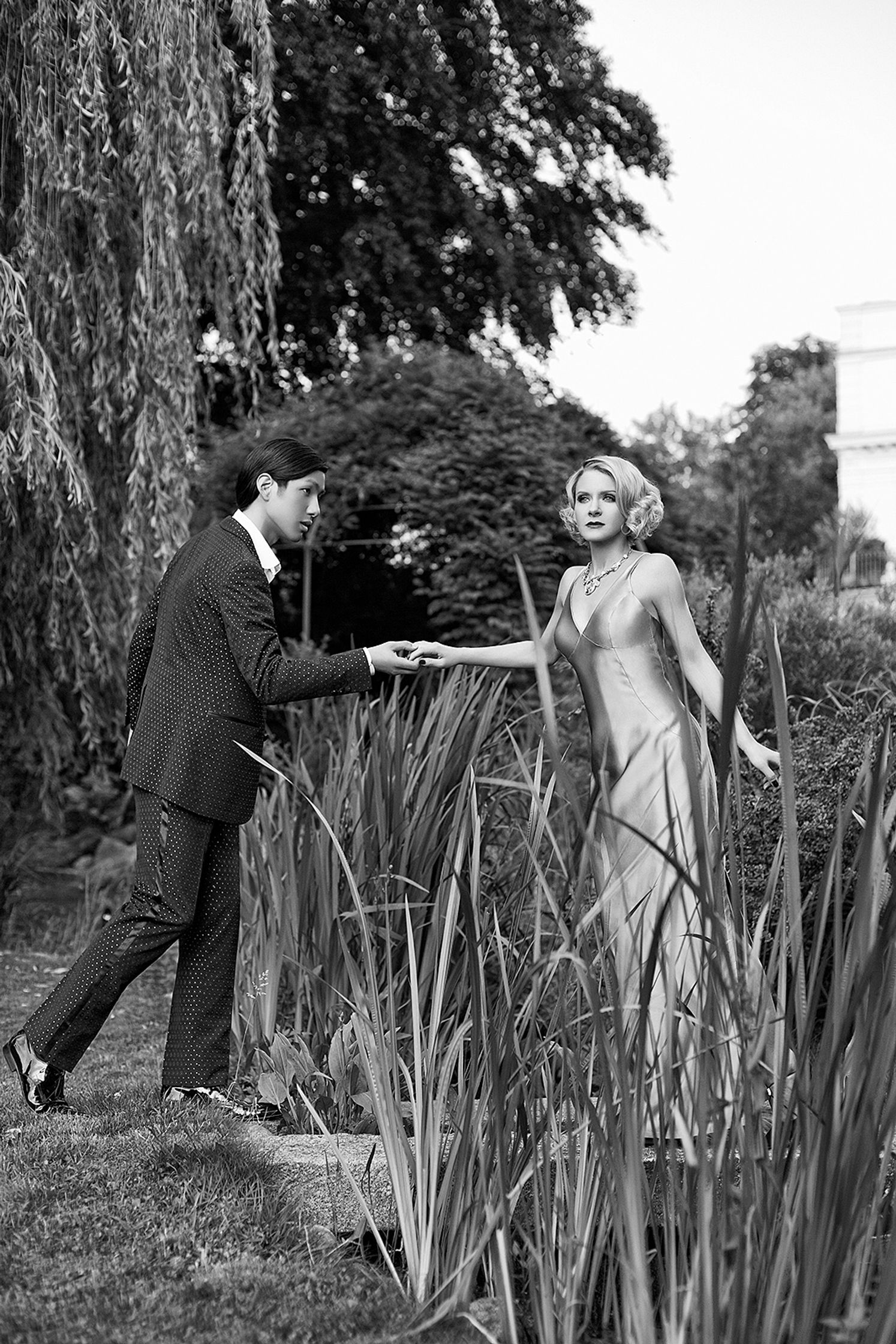 black and white photo of a man and woman holding hands in a pond advertising retouch hamburg