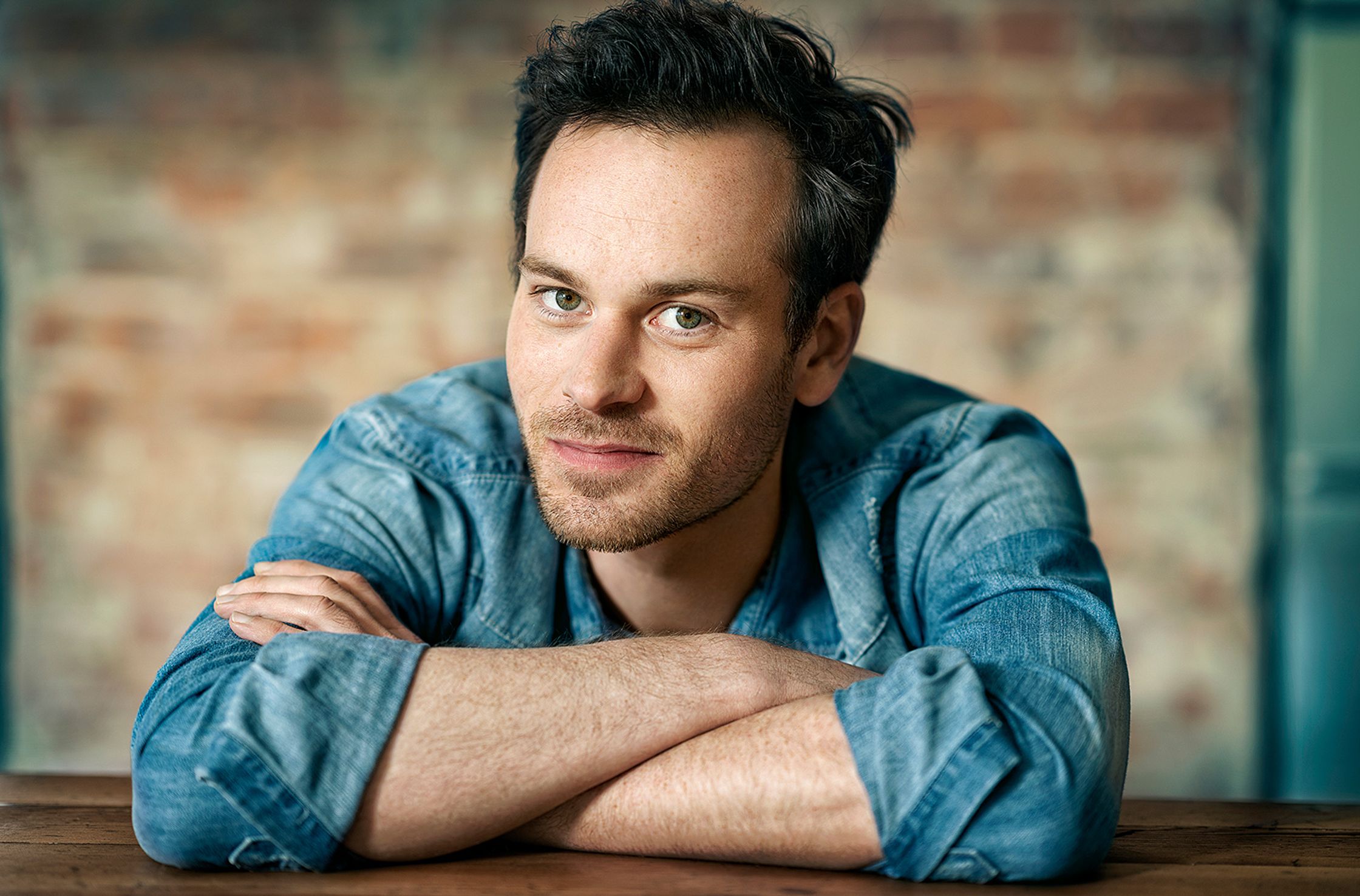 florian bartolomaei in a blue shirt leaning against a wooden table
retouche by glamtouch