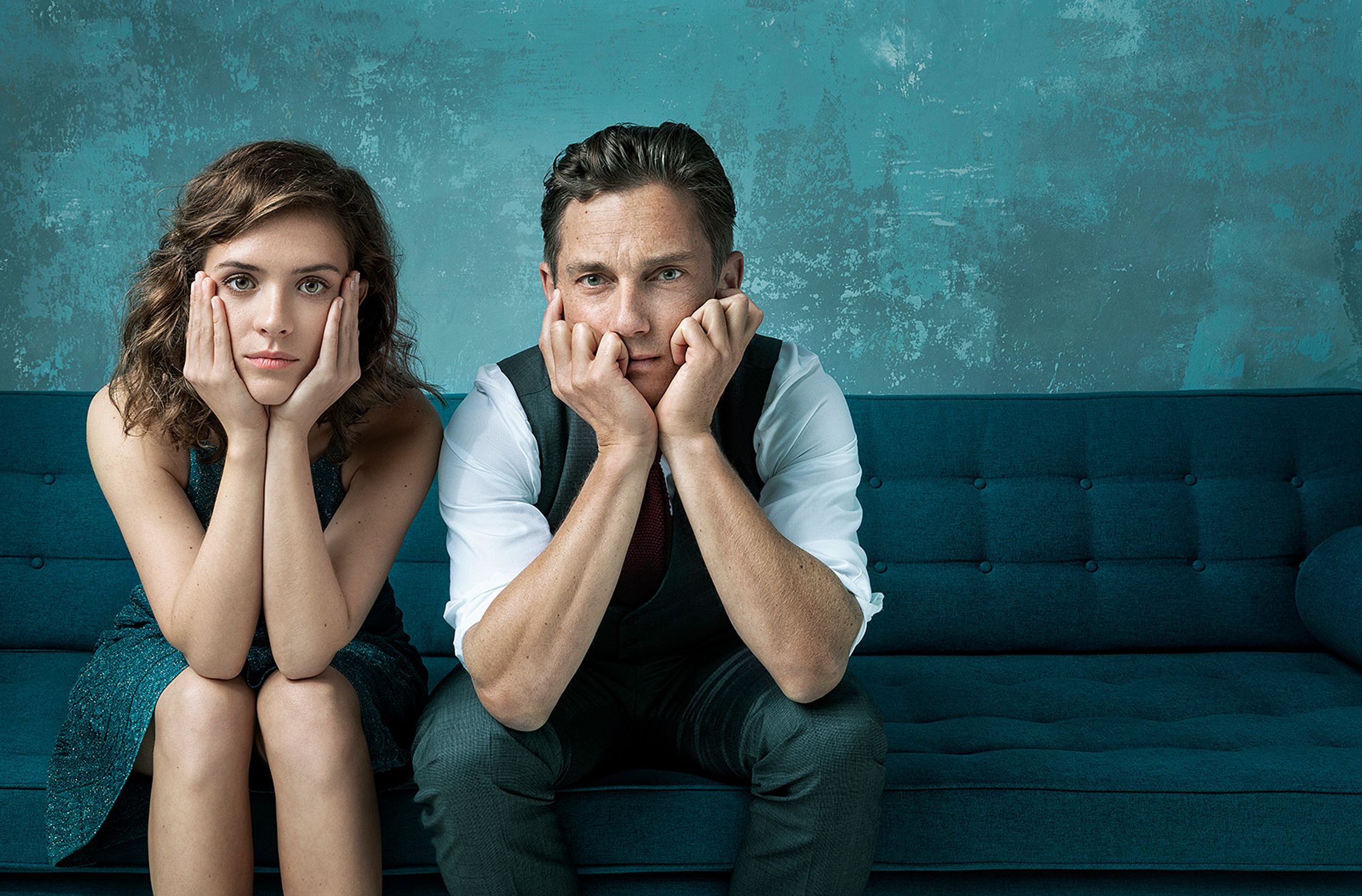 Liv Lisa Fries and Volker Bruch sitting on a blue couch with their hands on their faces
Retusche in Hamburg