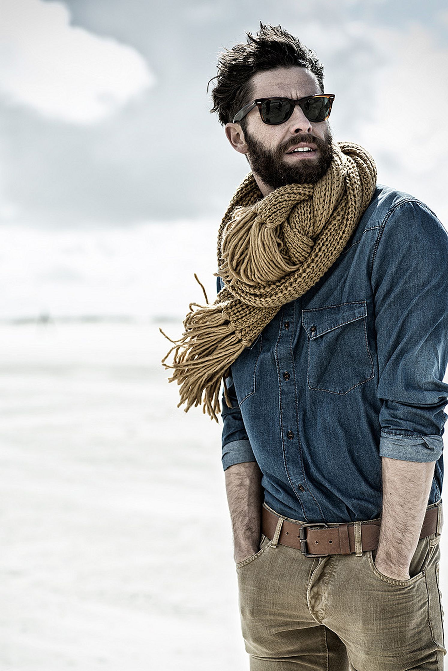 a man wearing sunglasses and a scarf in the desert post production image campaign