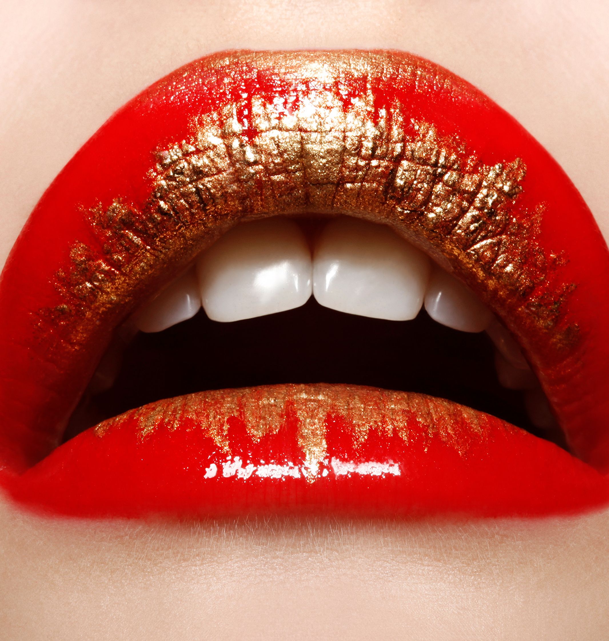 a woman's lips with red and gold paint on them glamour retouch