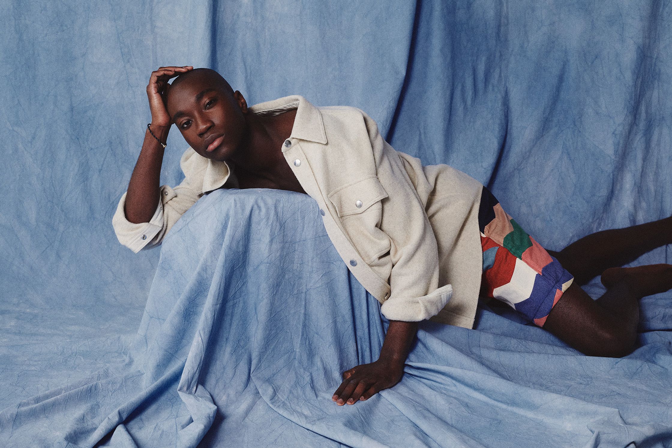 a man laying on top of a blue cloth