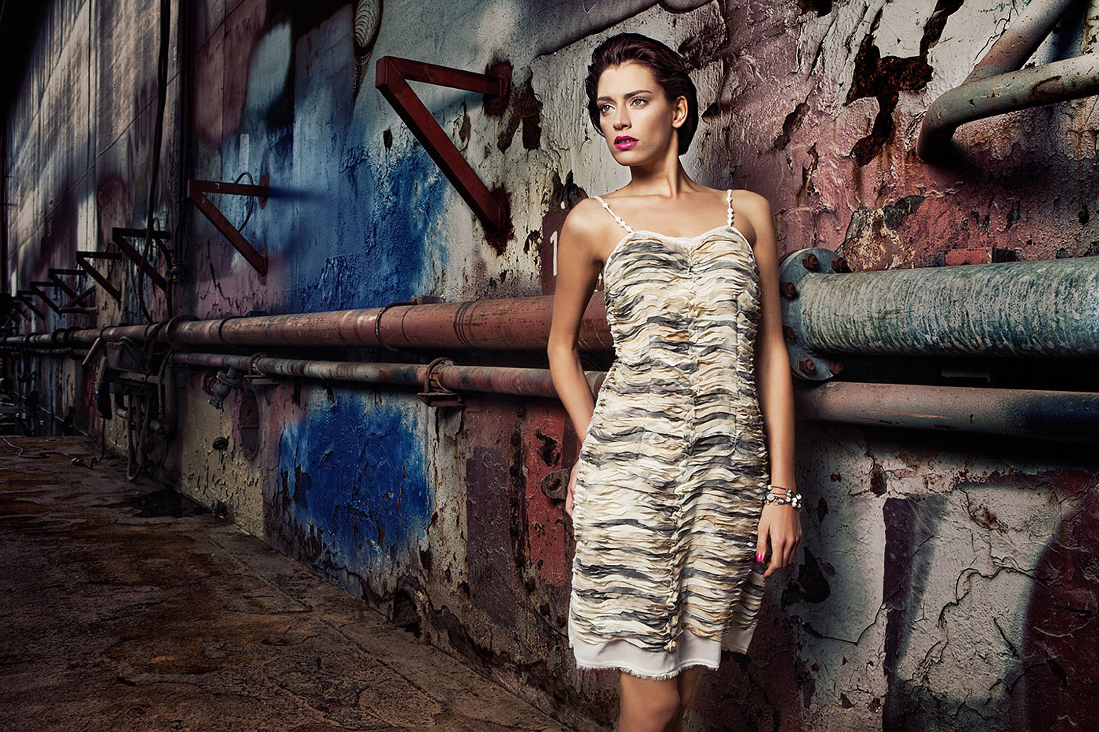 a woman in a dress leaning against a wall fashion image campaign