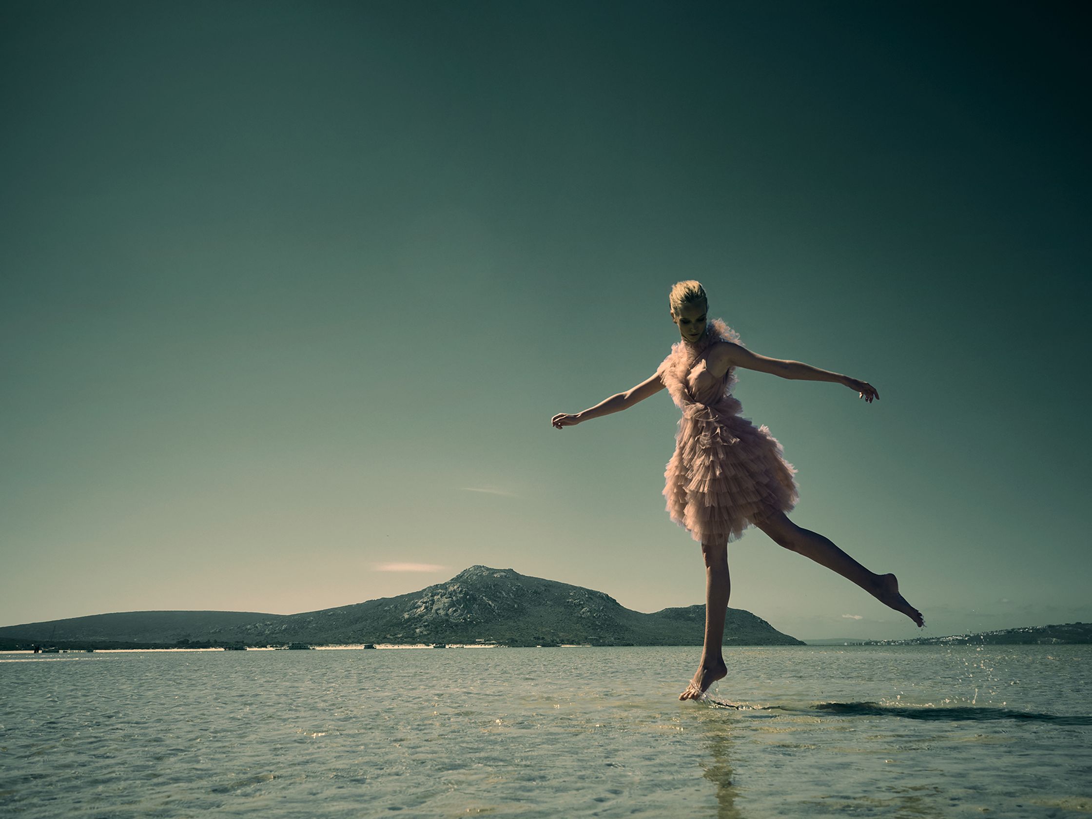 a girl in a pink dress is jumping in the water