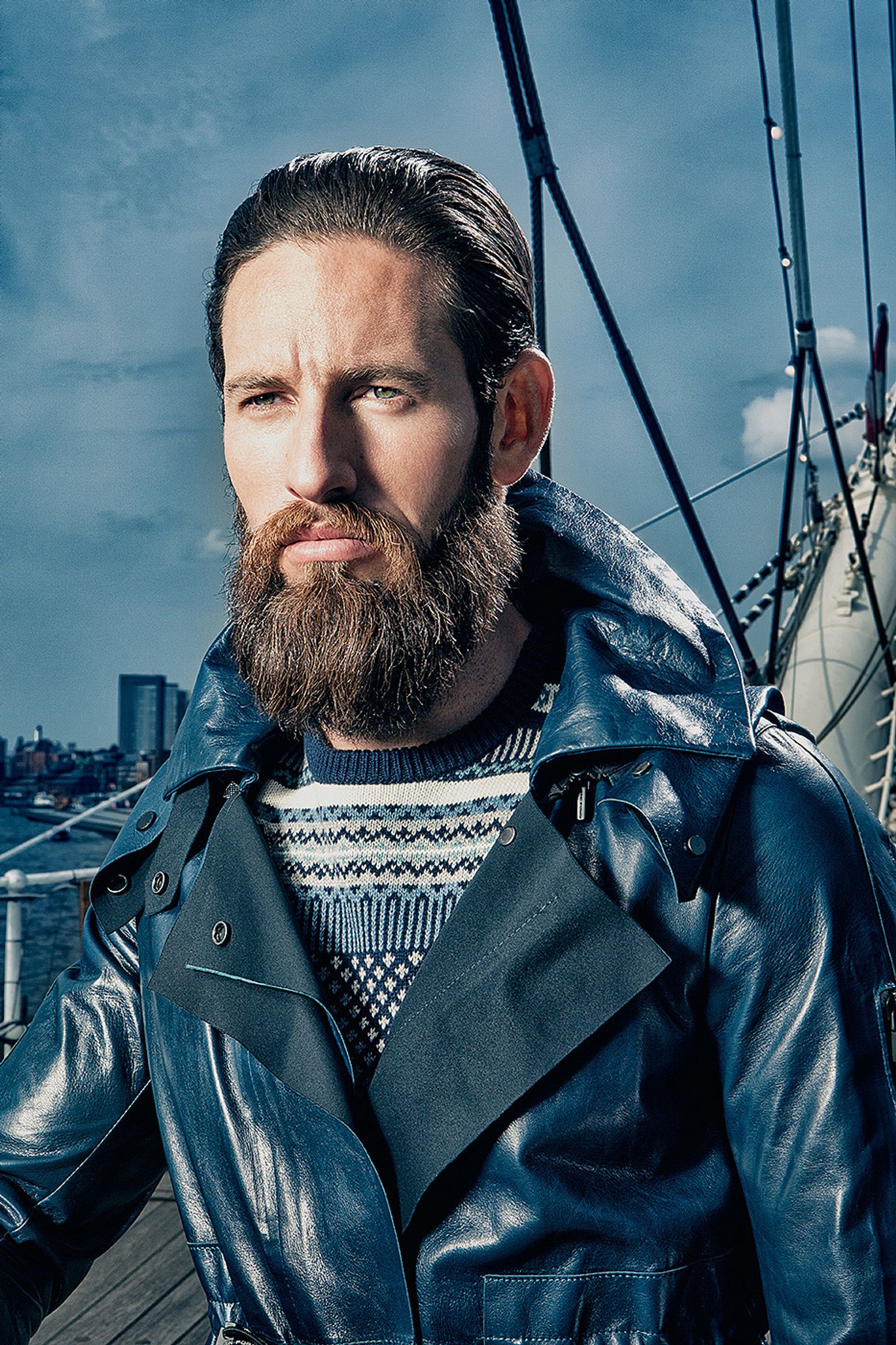 a bearded man in a blue jacket standing on a boat Creative Retouching Hamburg