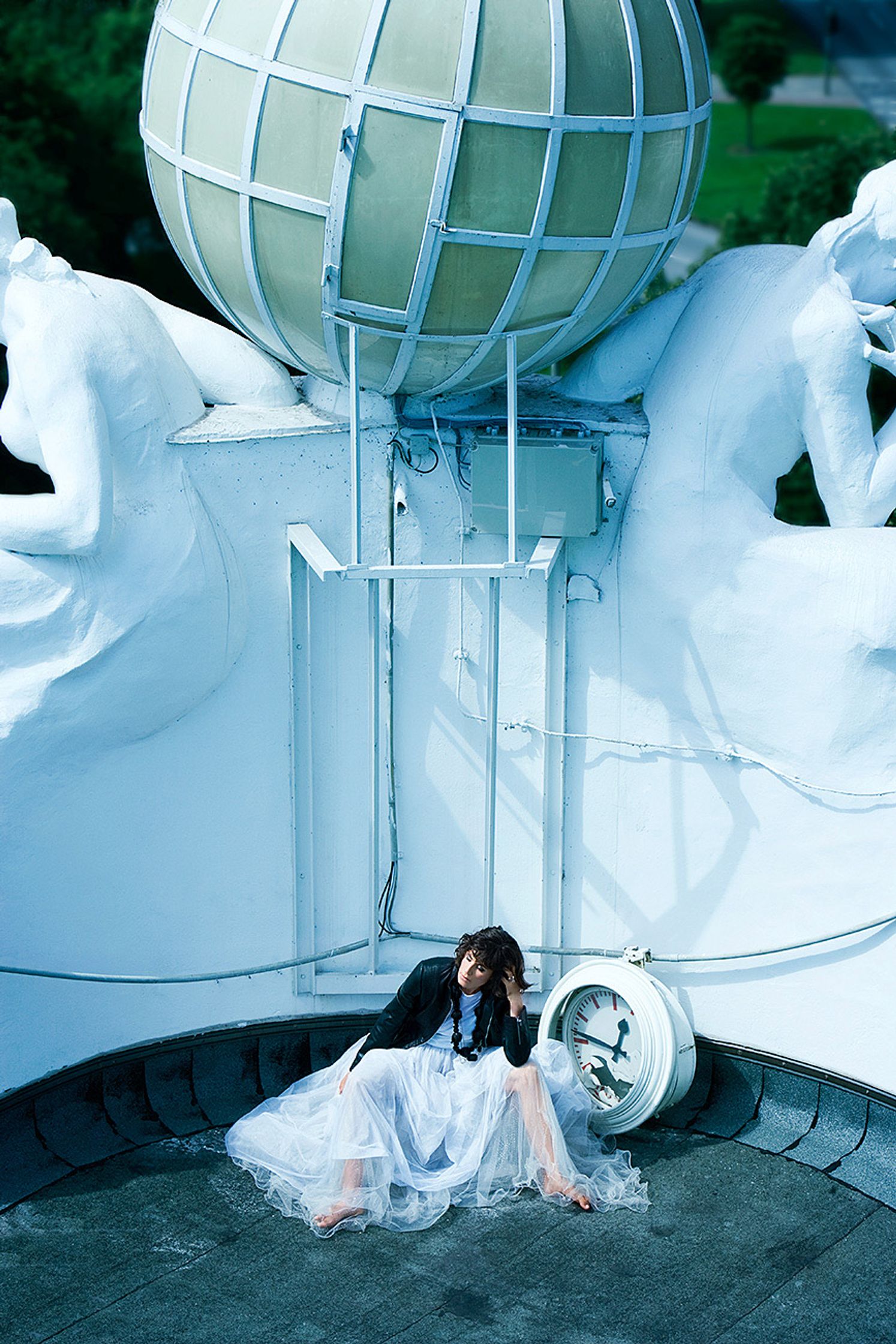 a woman in a white dress sitting on top of a globe  editorial fashion retusche