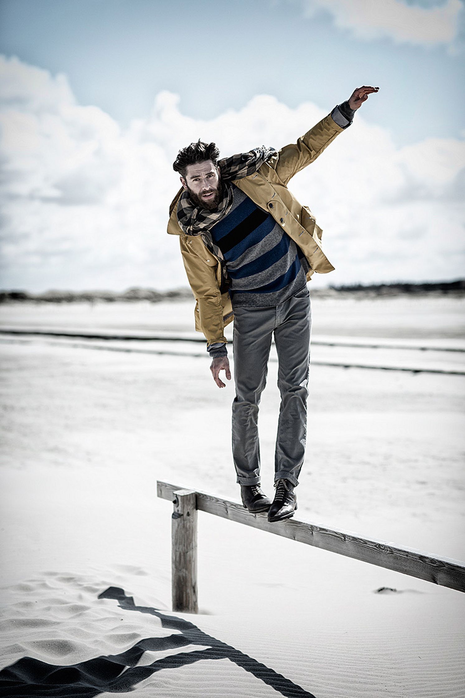 a man standing on a rail in the sand retusche image campaign