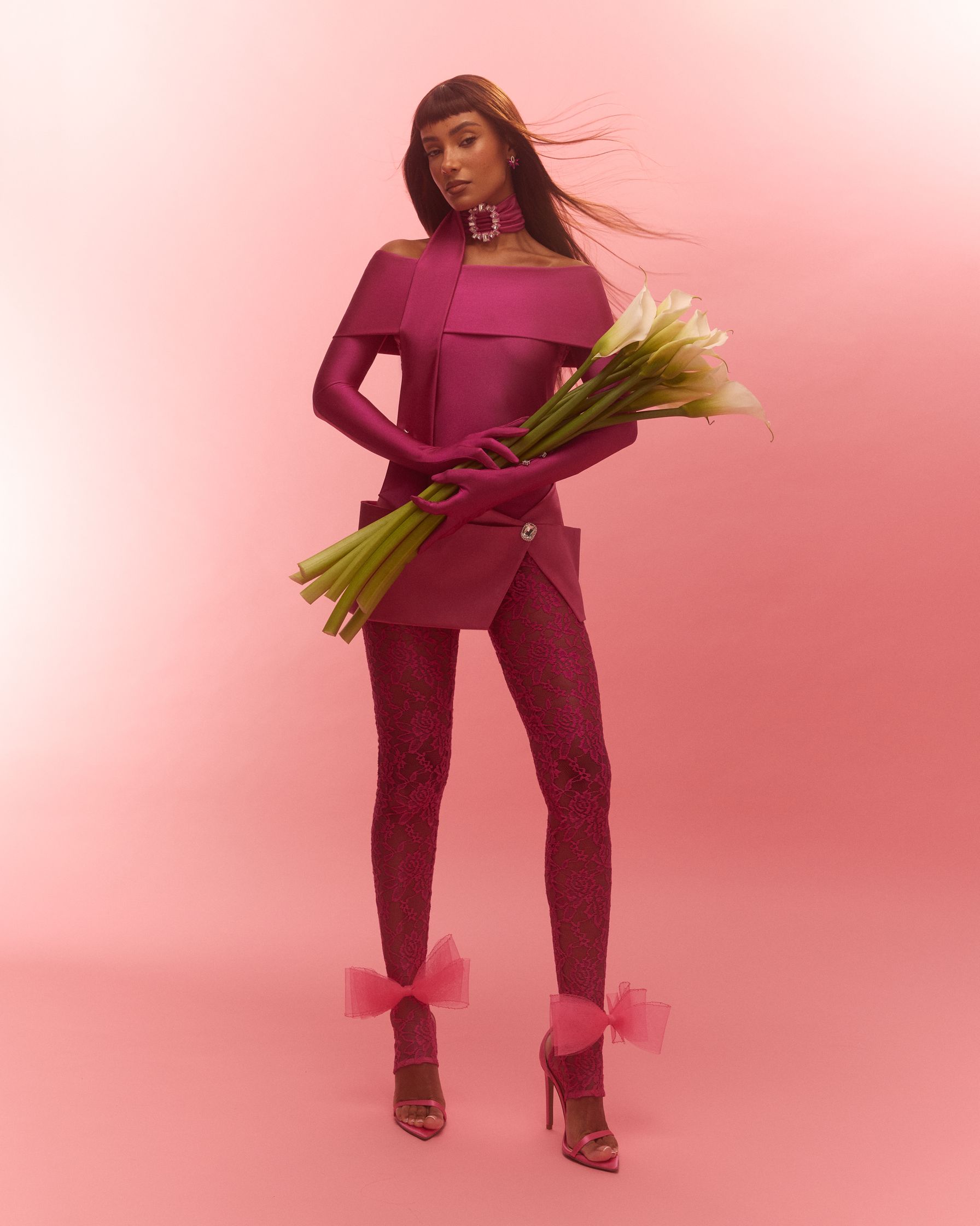 a woman in a pink outfit holding a bouquet of flowers