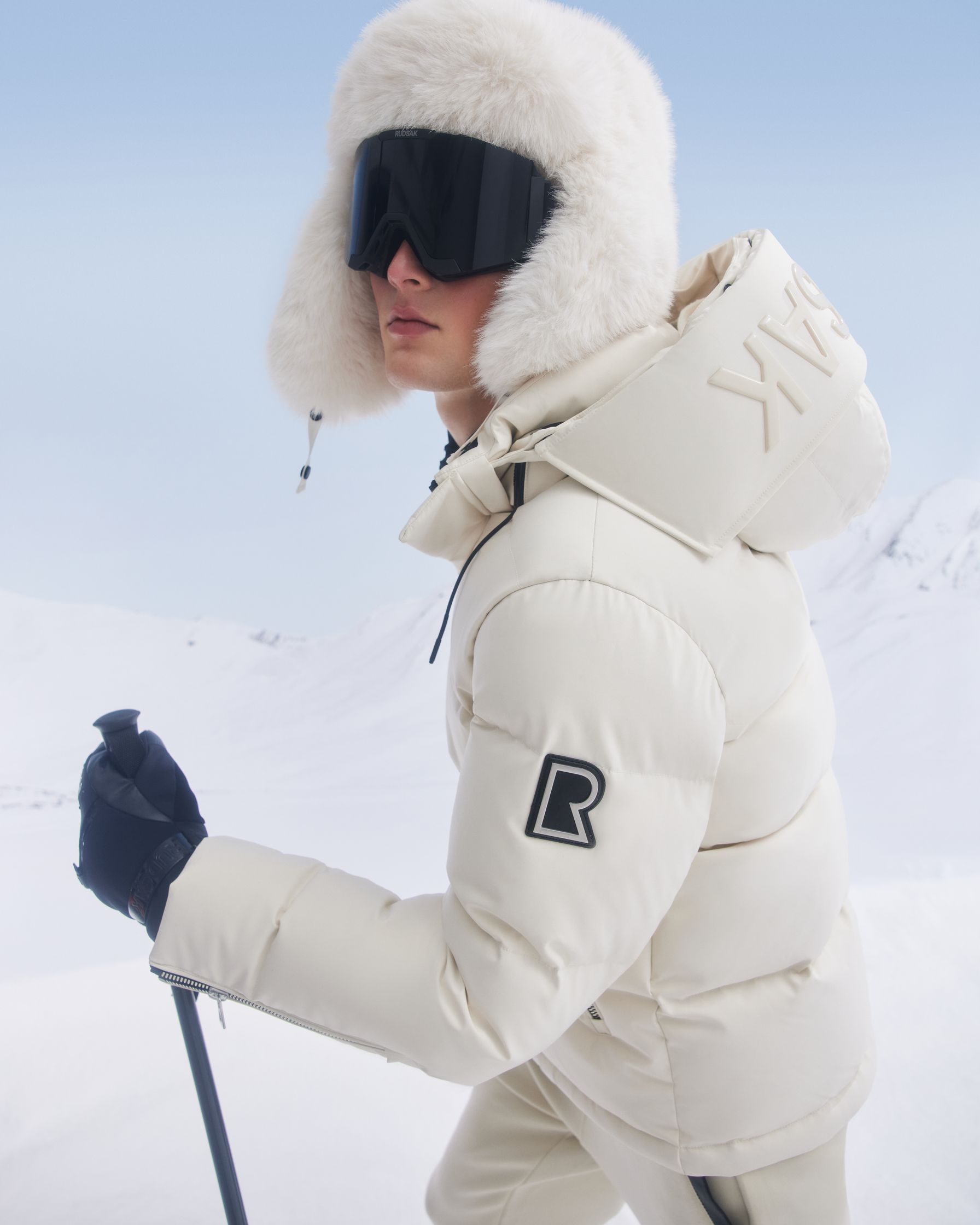 a woman wearing a white down jacket and skis