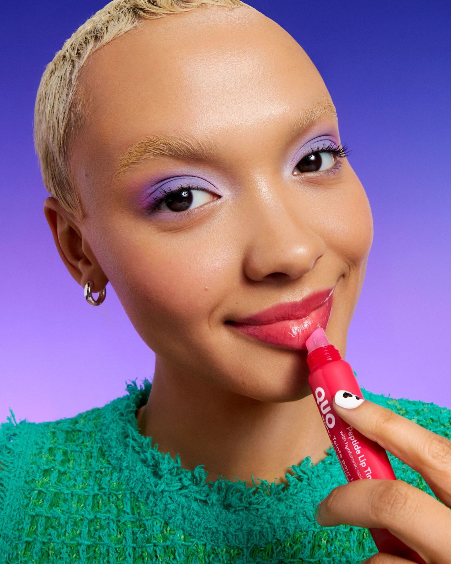 a woman is holding a lipstick in her hand