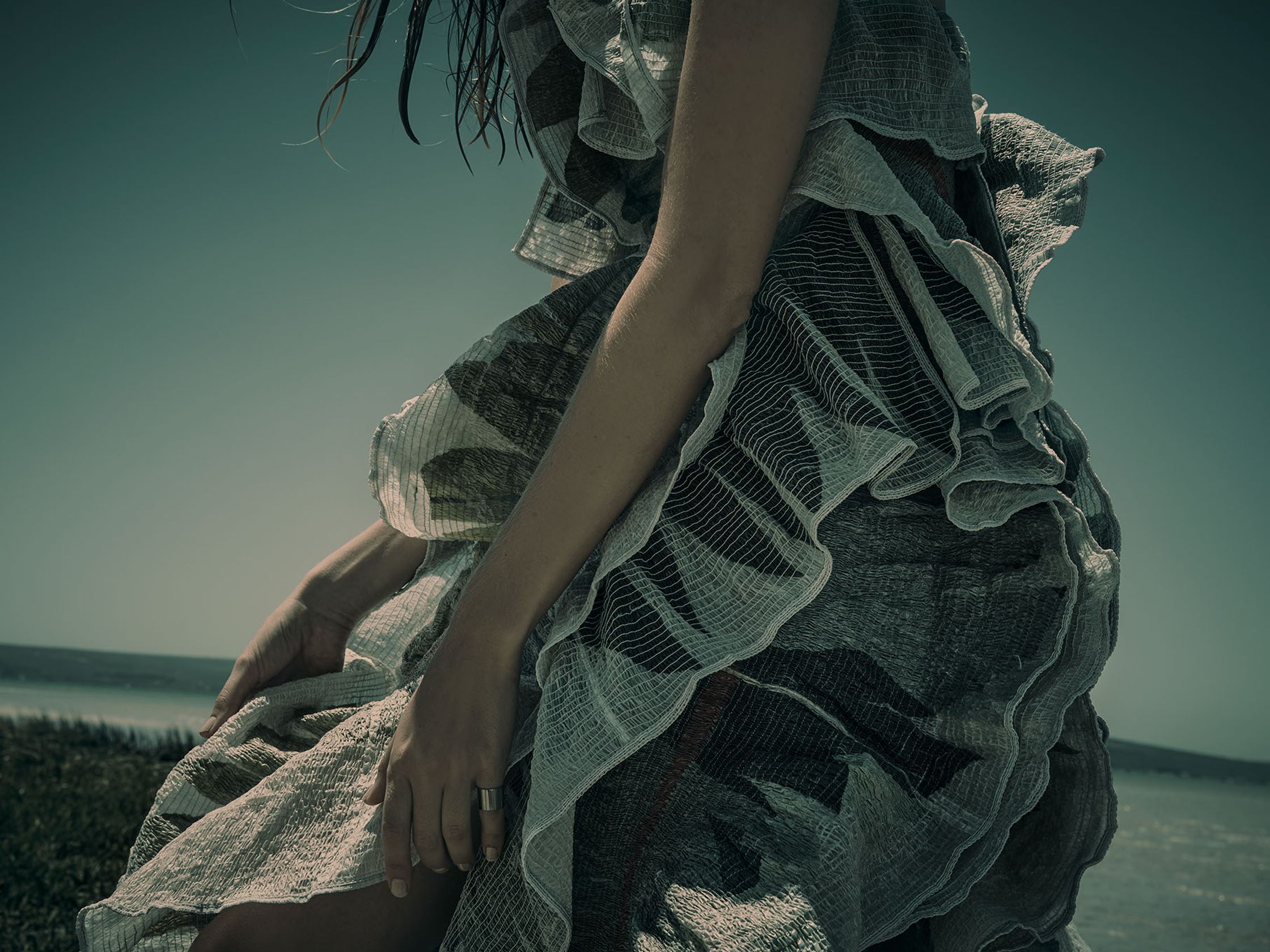 a woman in a dress standing on a beach