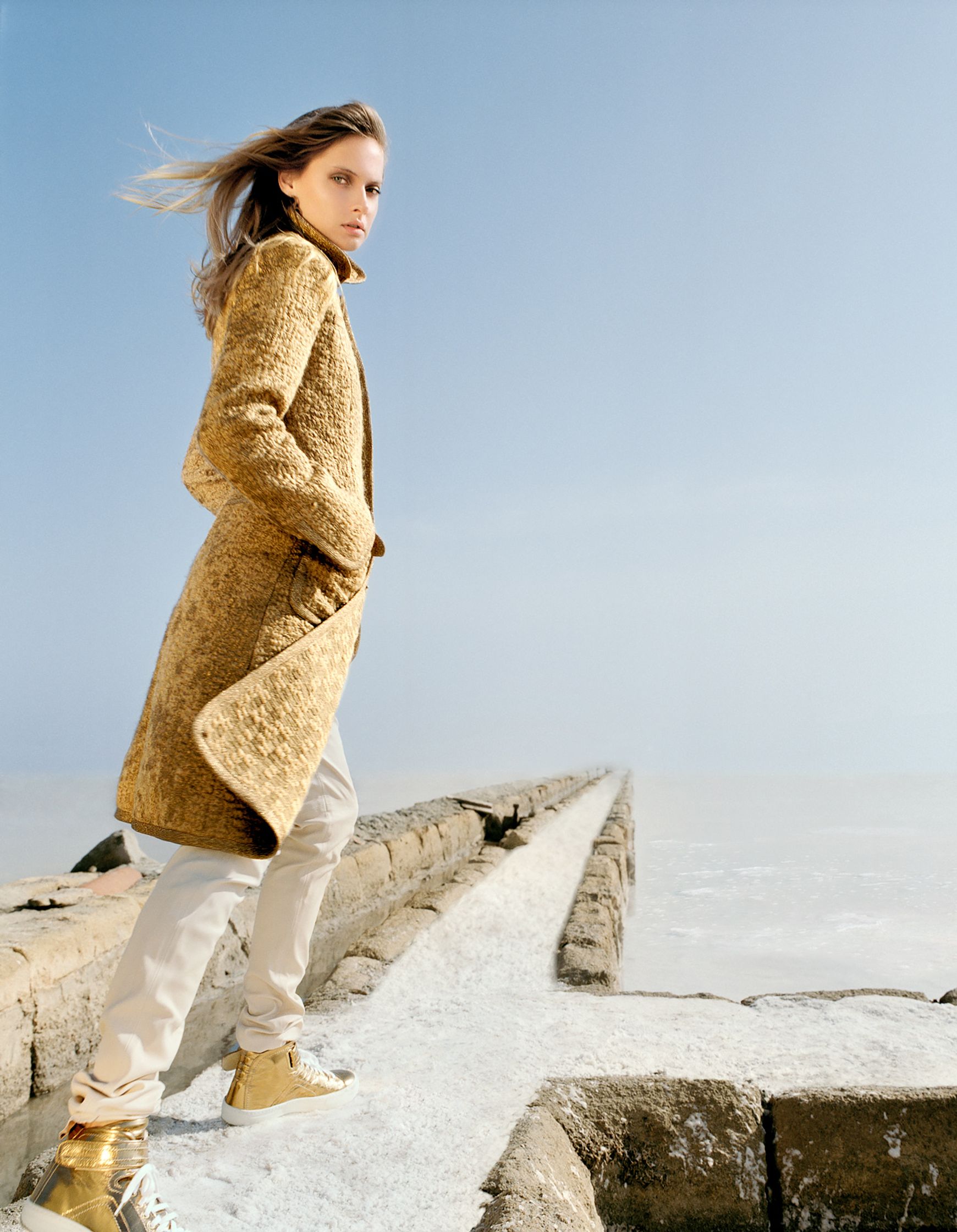 a woman in a yellow coat walking on a pier editorial retouching hamburg