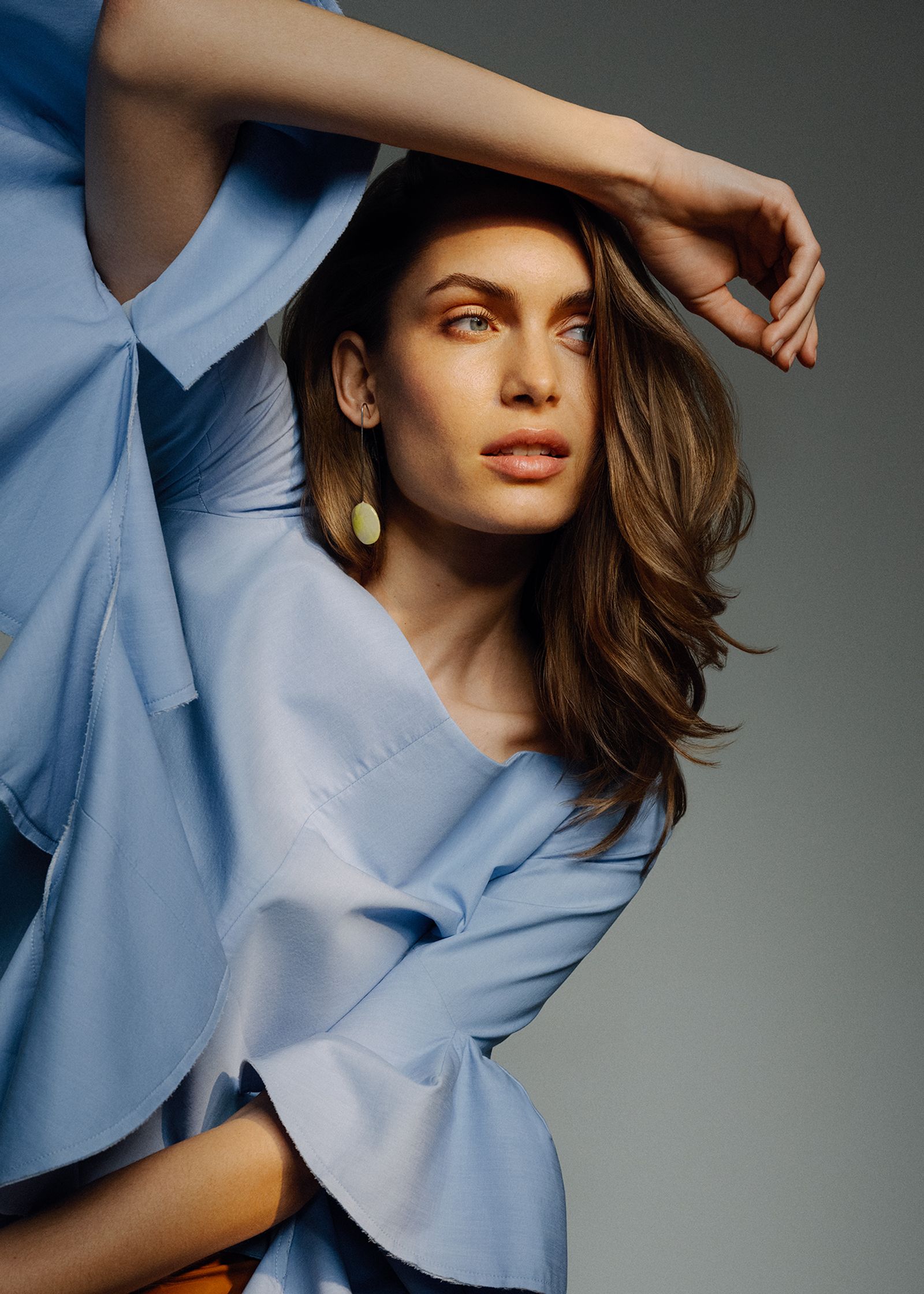 a young woman in a blue dress posing for a photo shoot