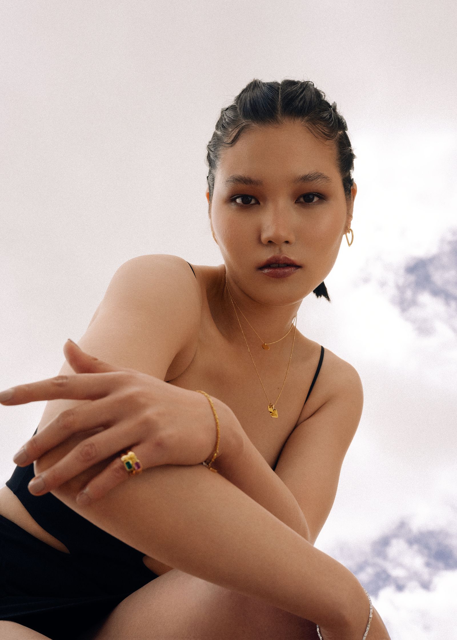 a woman wearing a black bikini and a gold ring