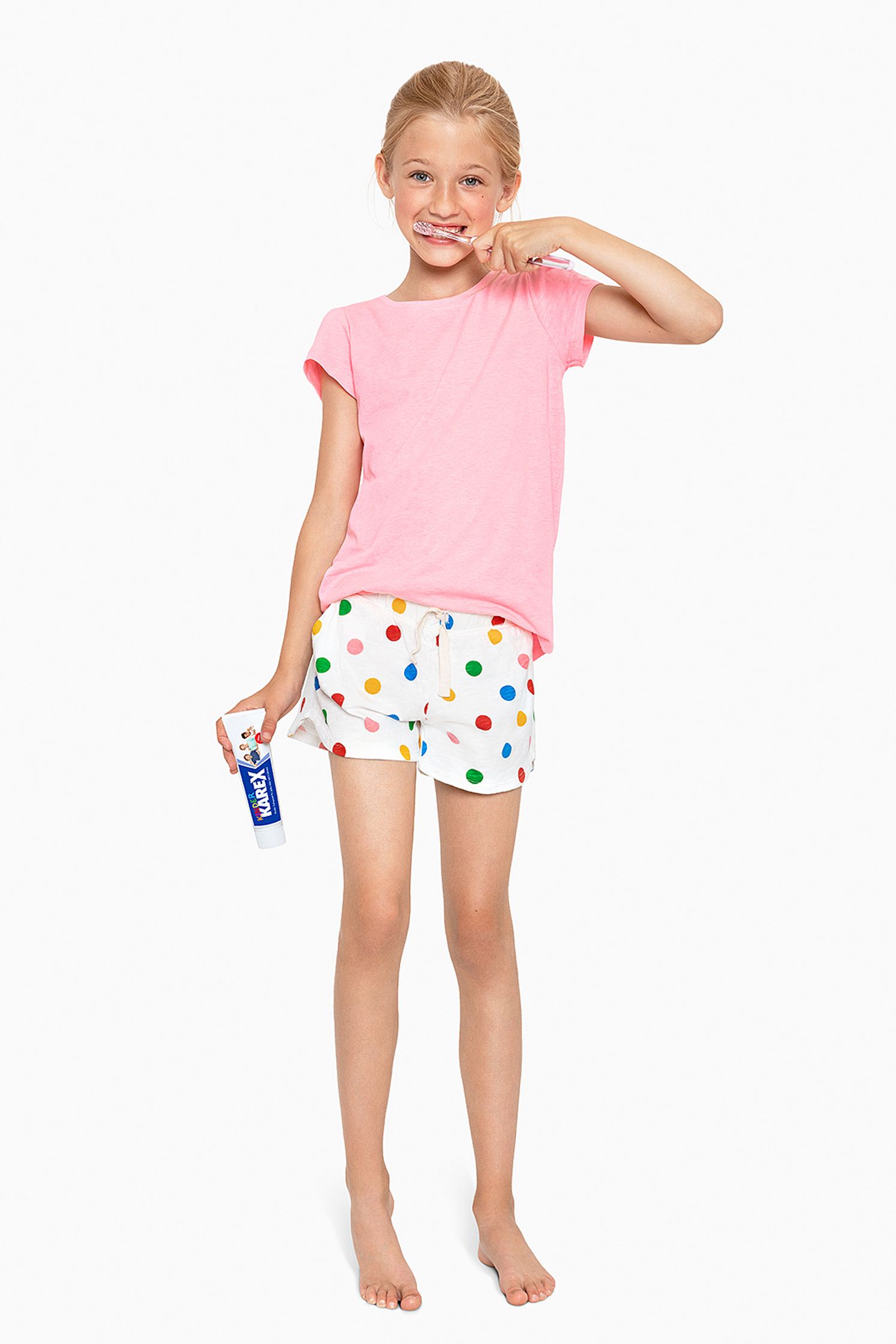 a girl wearing pink polka dot pajamas and holding a toothbrush - Bildbearbeitung Hamburg