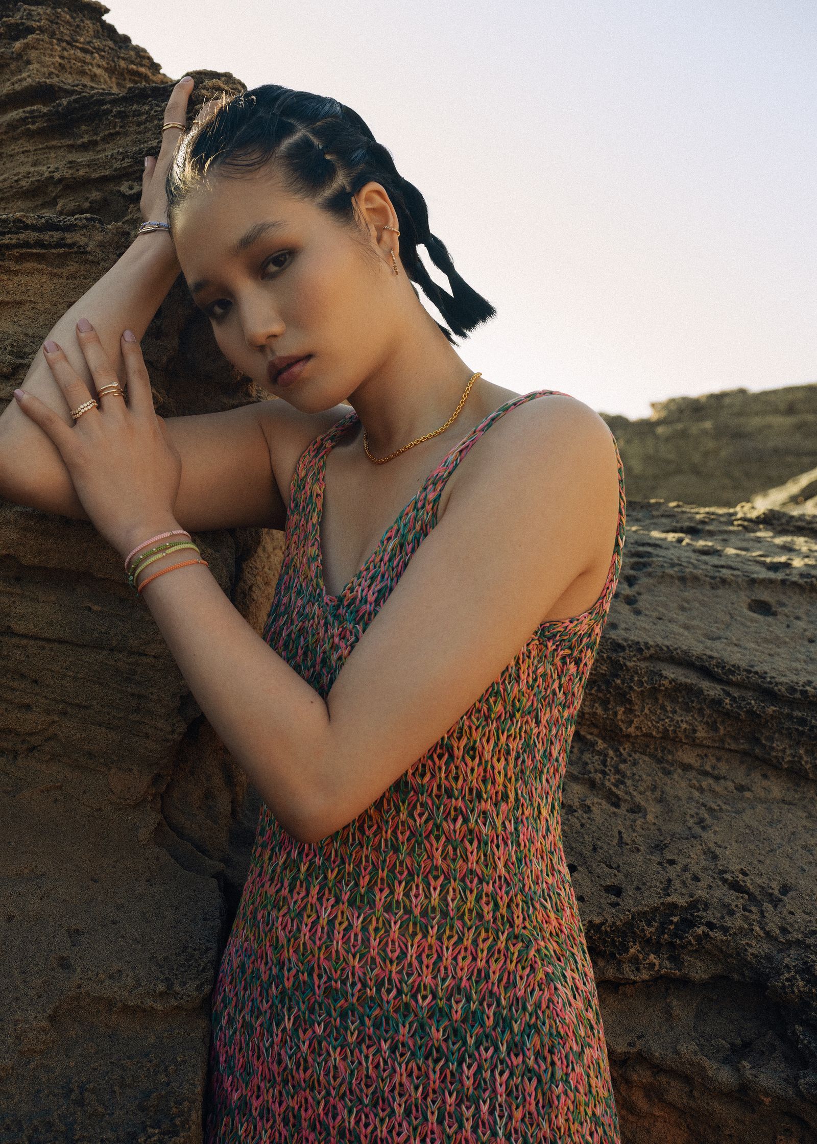 a woman is leaning against a rock