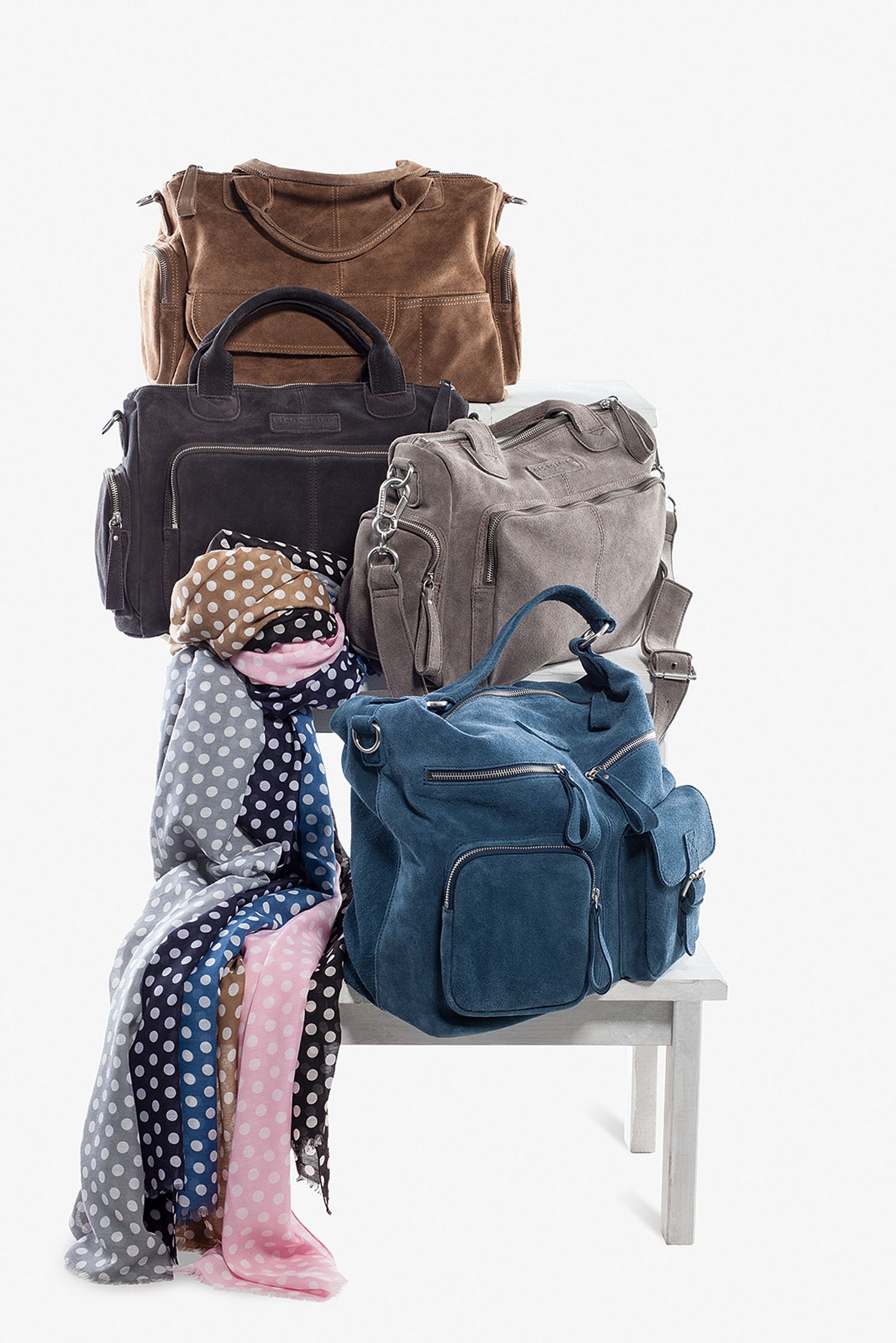 a group of bags and scarves on a white table Post Production Hamburg