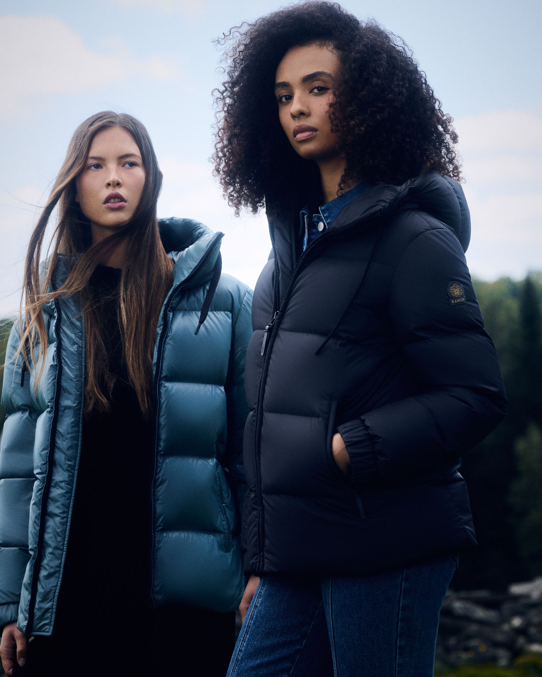 two women in puffer jackets standing next to each other