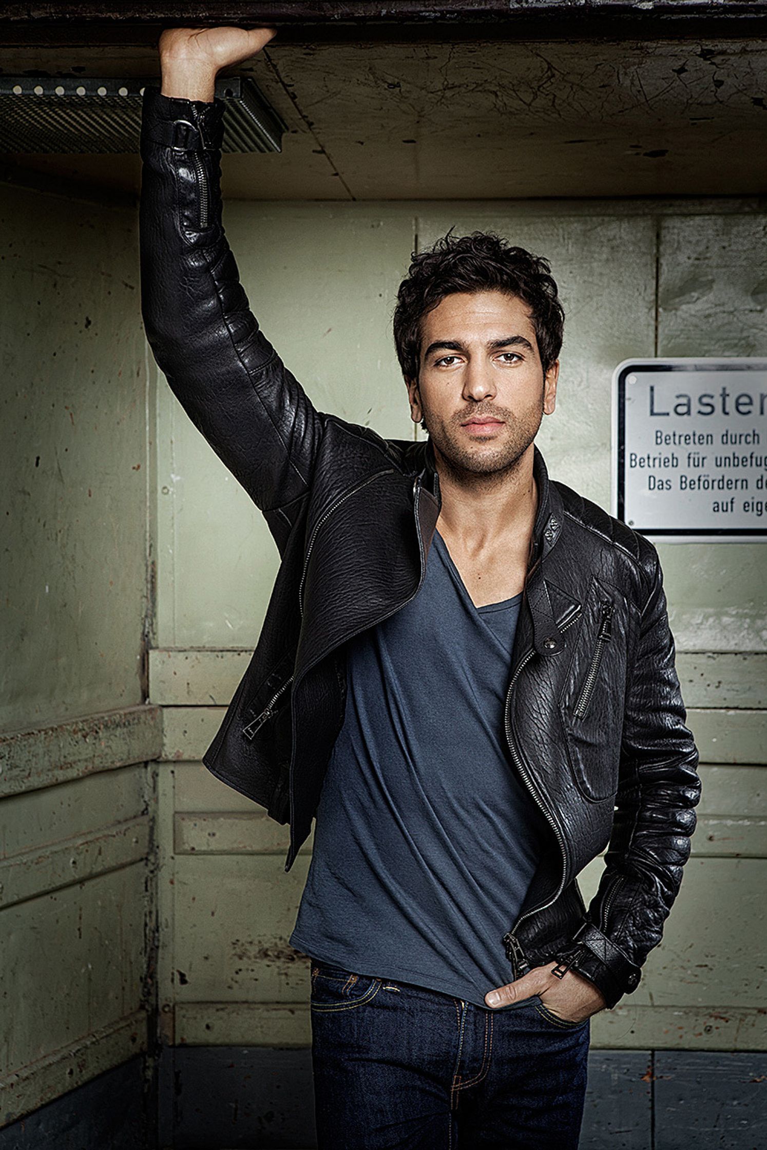 elyas m'barek in a leather jacket leaning against a wall
retusche by glamtouch