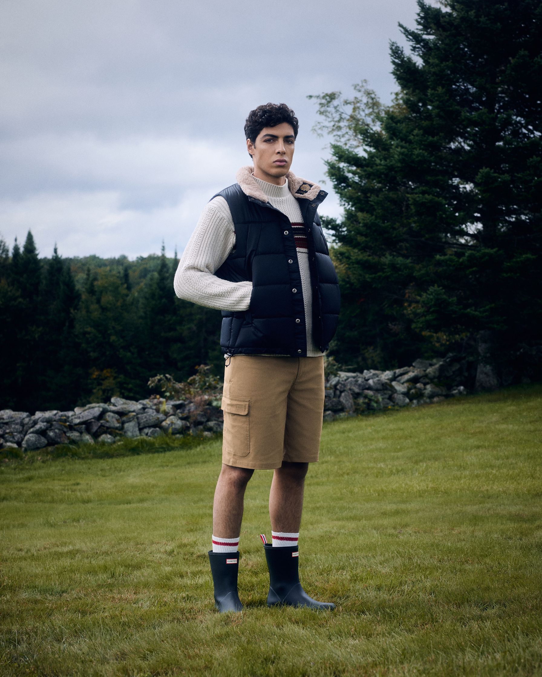 a man in a vest and shorts standing in a field